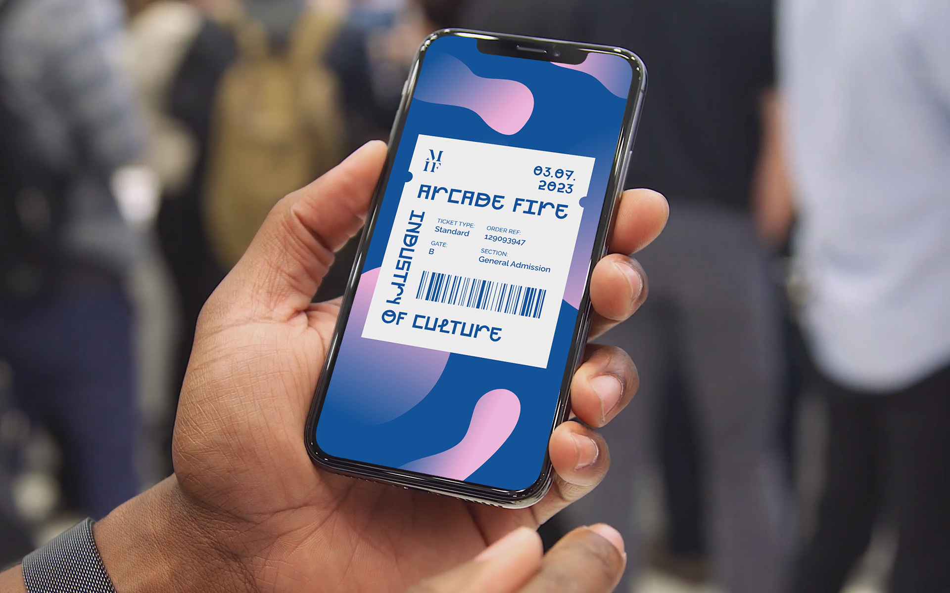 A man holding an iphone displaying an Arcade Fire Industry of Culture digital ticket