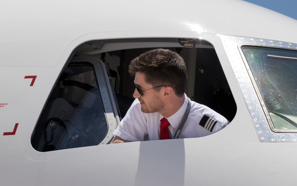 Milchstraße über den Wolken aus großer Flughöhe bei Nacht, aufgenommen aus dem Cockpit eines Flugzeugs auf über 11 000 Metern Höhe, Astrofotografie mit sichtbarem Sternenband über der Erde