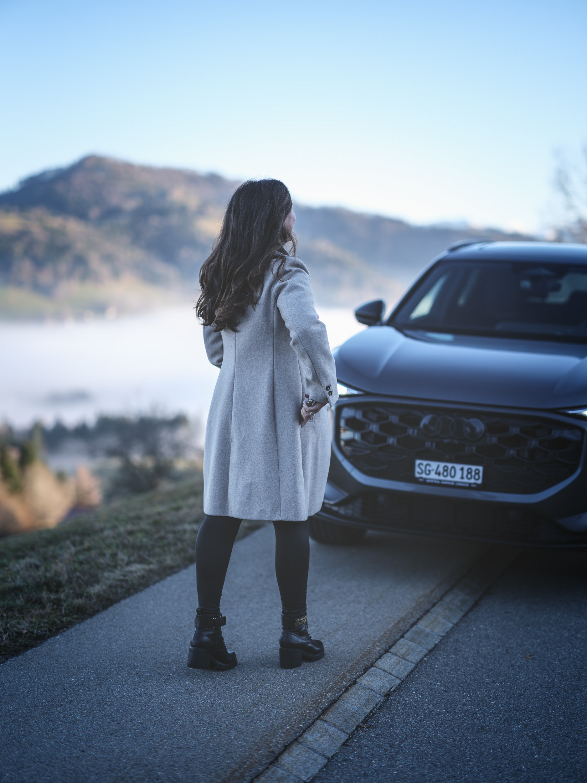 Audi Q3 Lifestyle Scene – Woman Standing by SUV Above Foggy Valley