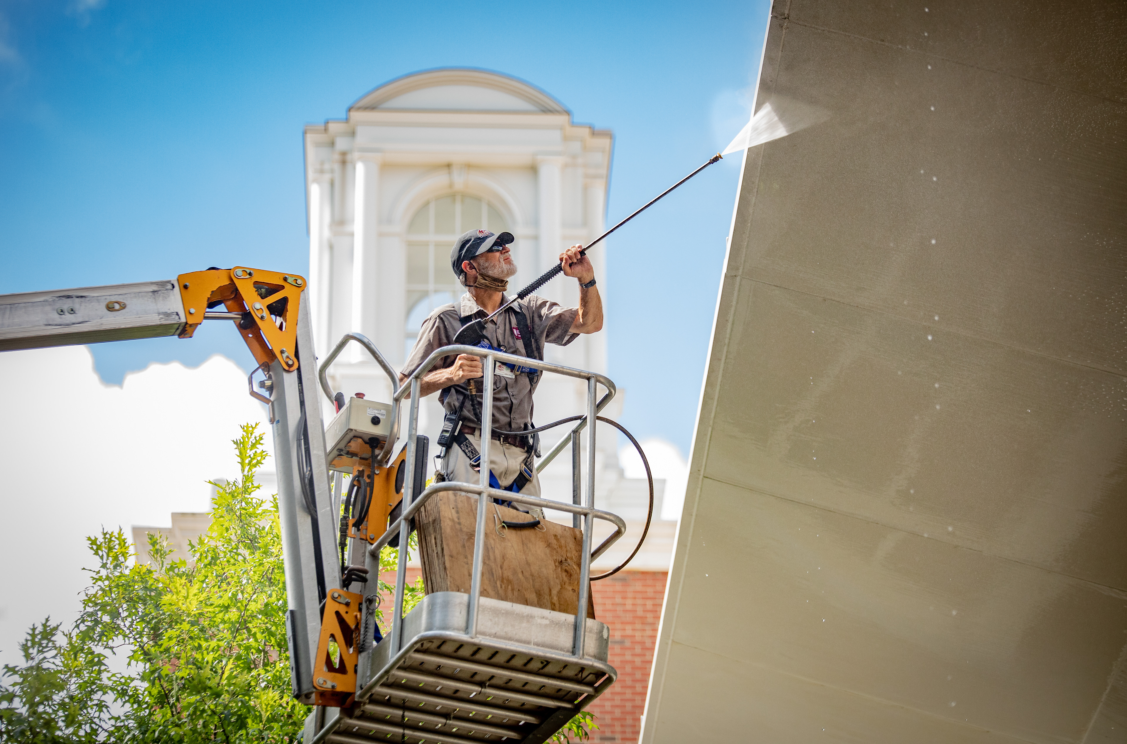 Jeff Brenner, a worker for Elon University Physical Plant, power washes the roof of Schar Atrium at Elon University.