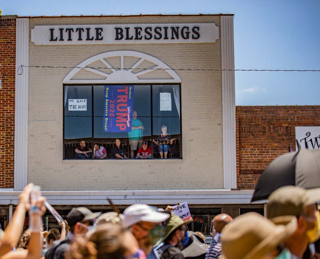 Observers in the Little Blessings Consignment Store in Graham watch the protest below.