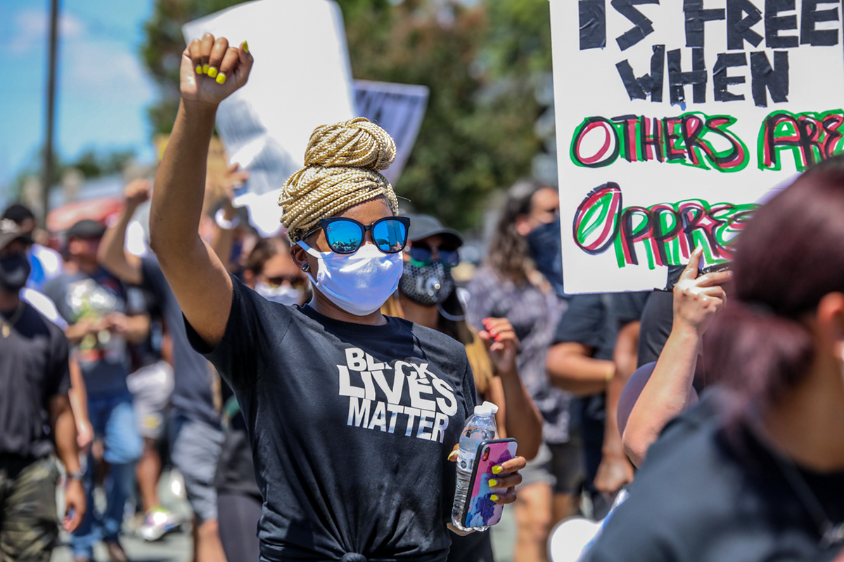 La Christian Vanhook of Burlington raises her fist in solidarity with Black Lives Matter as the protesters march to the Historic Courthouse in Graham.
