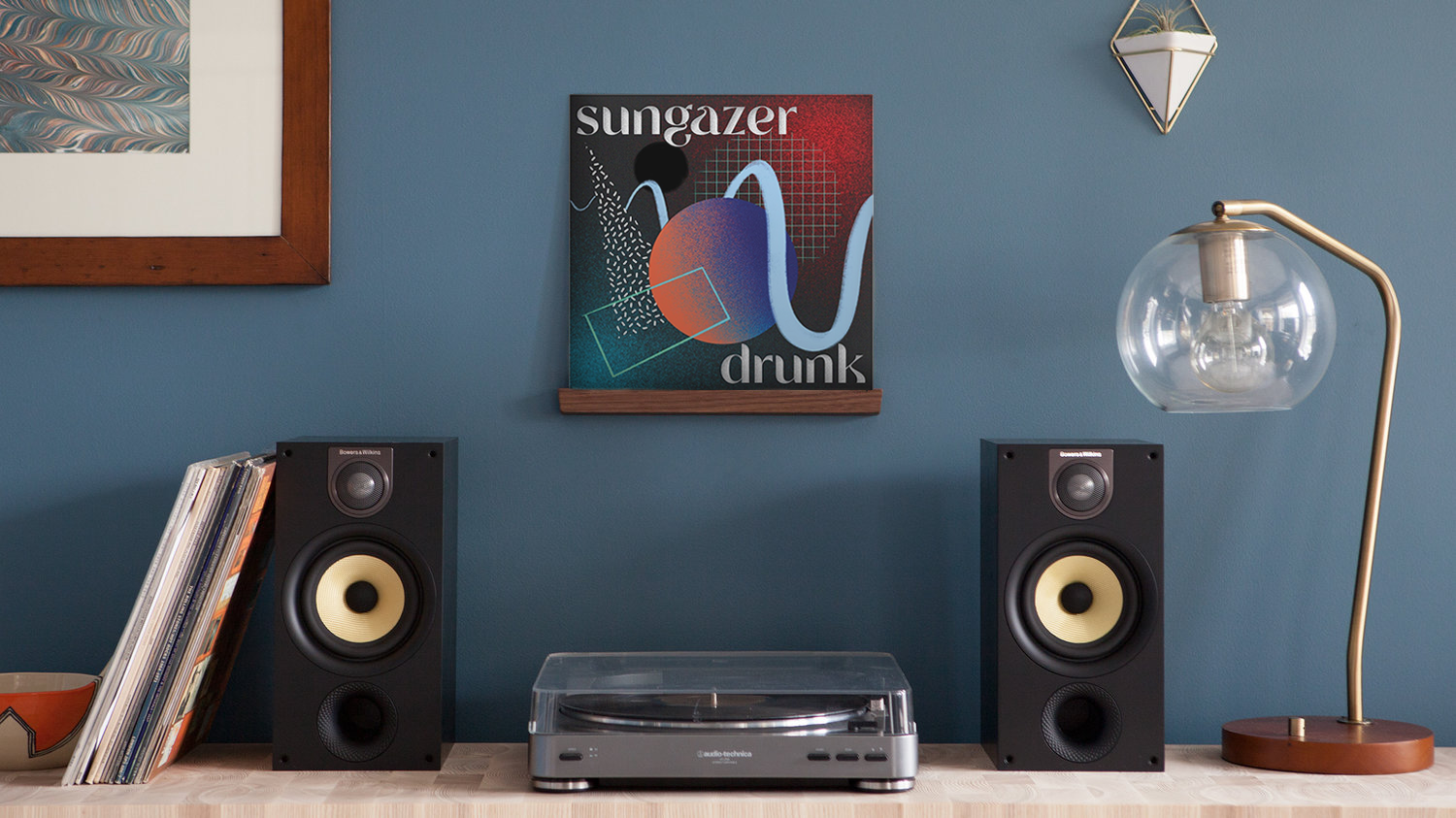 Vinyl record reading "sungazer: drunk" displayed above record player and two speakers