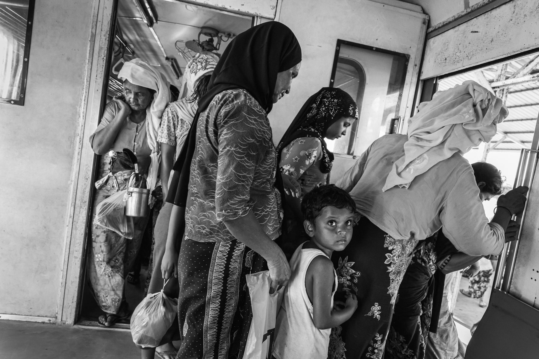 Rohingya minority travelling on the local train between the IDP camps. They are not allowed to travel to Sittwe and the trains are guarded by heavily armed police forces. Sittwe township, Myanmar, September 2019