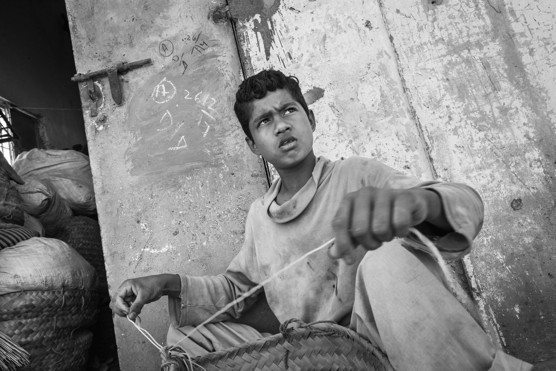 A boy sorting out fishing nets. A lot of Rohingya in Karachi for the past forty years make a living of fishing and related industries. Arkanabad, Pakistan, March 2018