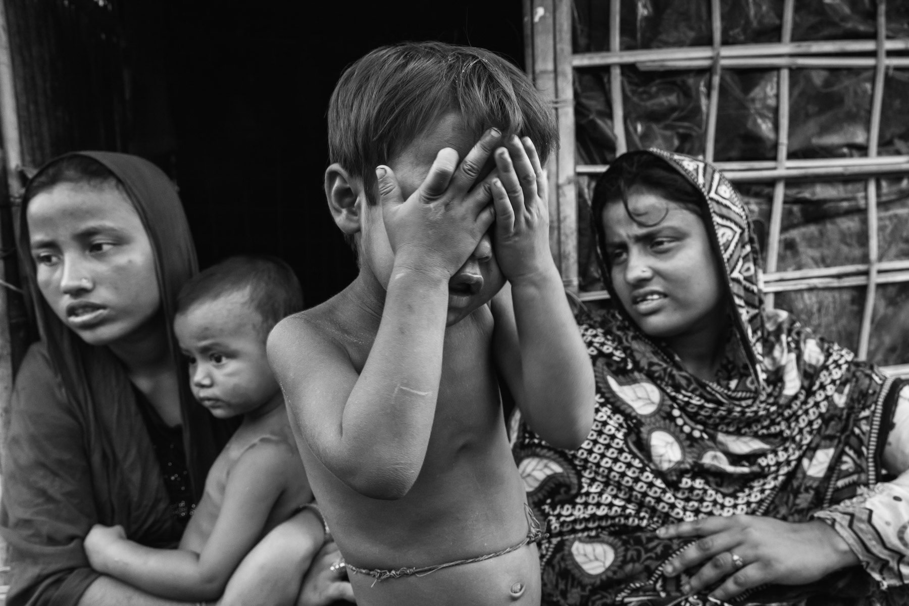 Nurkolima (left), 18 years, and Kathar Begum, 23 years are sisters. Their husbands were arrested, having no news they presume they were killed. Their mother is still in Myanmar because they didnt have enough money to pay their passage to Bangladesh. They were raped and tortured, 15 days ago, when the Myanmar army came to their village to search for valuables. They arrived 5 days ago in Shamlapur and paid 70US$ to cross the border with their 3 children. Countless rape allegations have been consistently reported during the past months, an accusation the Myanmar authorities deny. Mass rape is often used during ethnic cleansing camoaigns, both acts consitute crimes against humanity and war crimes when carried out by military personnel. Shamlapur refugee camp, Bangladesh, May 2017