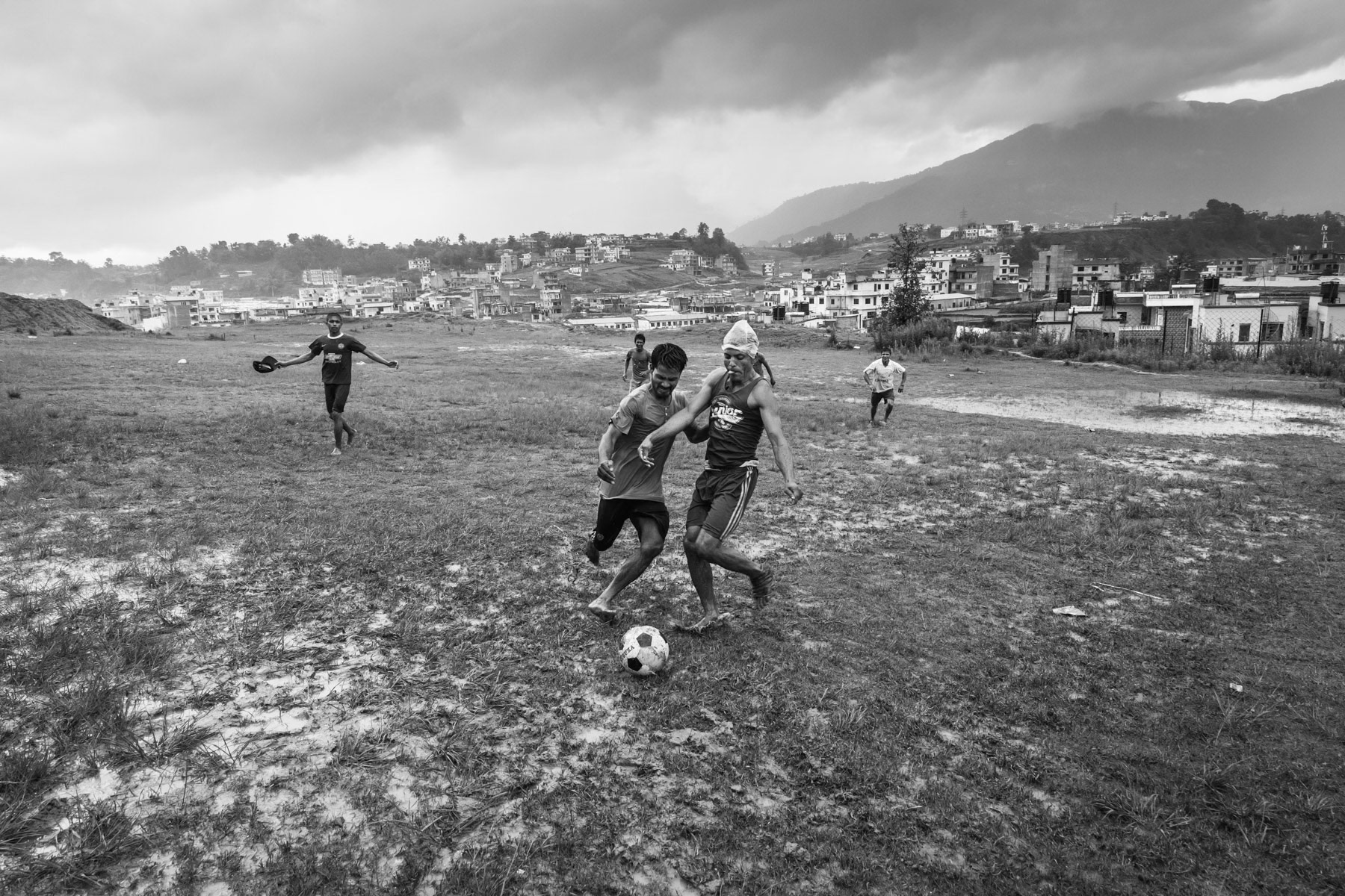 Rohingya refugees from Myanmar playing football at the beginning of the monsoon season. Kathmandu Valley, Nepal, July 2017