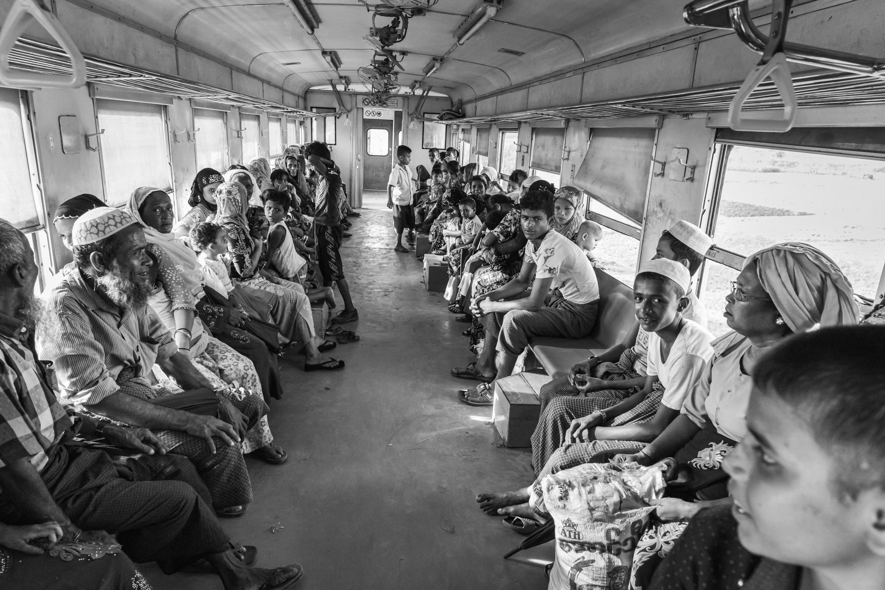 Rohingya minority travelling on the local train between the IDP camps. They are not allowed to travel to Sittwe and the trains are guarded by heavily armed police forces. Sittwe township, Myanmar, September 2019