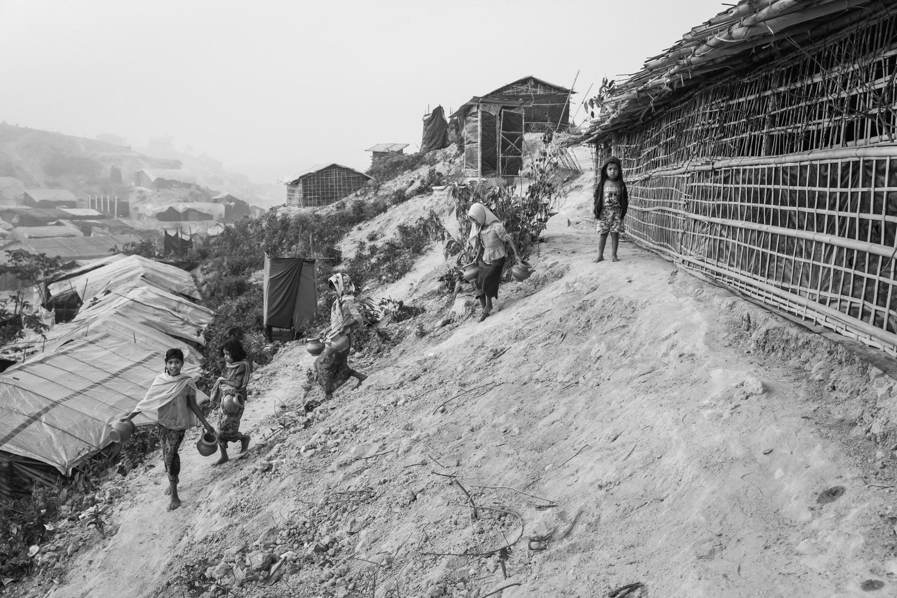 Rohingya children going to collect water from one of the few tube wells in the refugee camp for new arrivals. More than 650,000 Rohingya refugees have arrived in Bangladesh since August 2017. Thangkhali refugee camp, Ukhiya, Bangladesh, March 2018