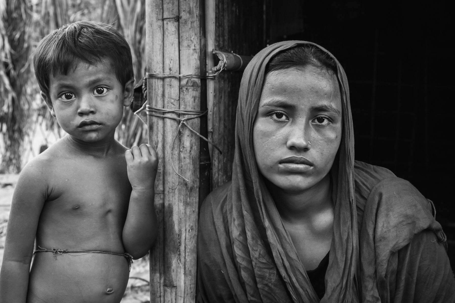 Nurkolima, 18 years, and her son. Her husband was arrested and she presumes he was killed. Her mother is still in Myanmar because they didnt have enough money to pay their passage to Bangladesh. She was raped and tortured, 15 days ago, when the Myanmar army came to their village to search for valuables. She arrived 5 days ago in Shamlapur and paid 70US$ to cross the border with her sister and their 3 children. Countless rape allegations have been consistently reported during the past months, an accusation the Myanmar authorities deny. Mass rape is often used during ethnic cleansing camoaigns, both acts consitute crimes against humanity and war crimes when carried out by military personnel. Shamlapur refugee camp, Bangladesh, May 2017