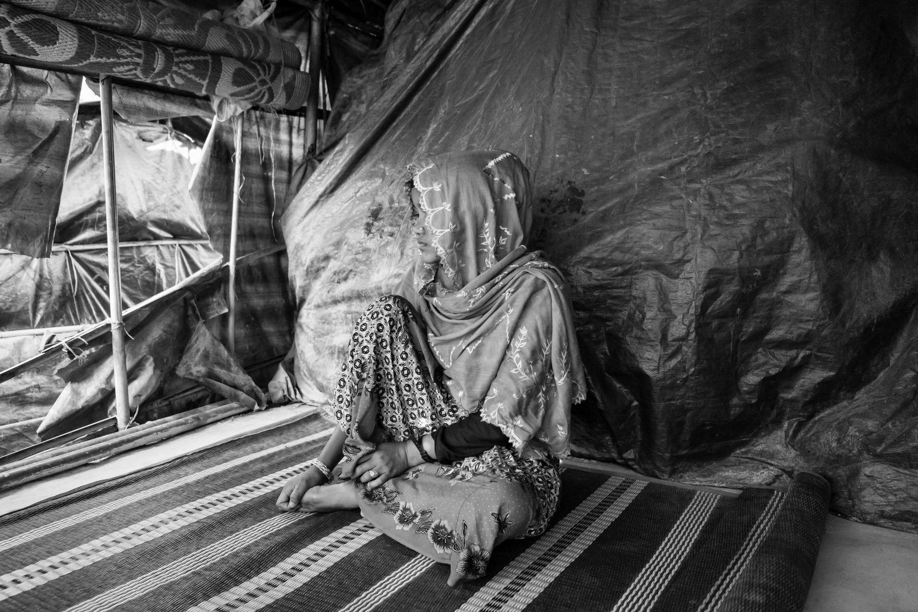 Sufayra Begun, 20 years, from Chut Pyin, Rathedaung. Got married one month before the attack in August 2017. Her husband was shot and killed, along with her father in law and brother by the military. Together with other women and girls she was taken blindfolded and tight to a shed where they would be gang-raped by the military and local rakhine mobs for several hours. Few of them were killed while being abused. Together with eight other women she managed to escape and returned near the village to find family that had survived the massacres. Although she was blindfolded she has recognized the voices of the non-military rapists, all were local Rakhine from the same village. It took her nearly a week to reach Bangladesh in September 2017. She now lives alone with her 4 year old sister, her mother lives in another block of the camp. Chut Pyin village is one of the numerous Rohingya villages that have been totally wiped out and where severe acts of ethnic cleansing with genocidal intend have been committed by the military and local mobs. Hundreds of Rohingya have been massacred in this village alone. Tangkhali camp, Bangladesh, March 2018