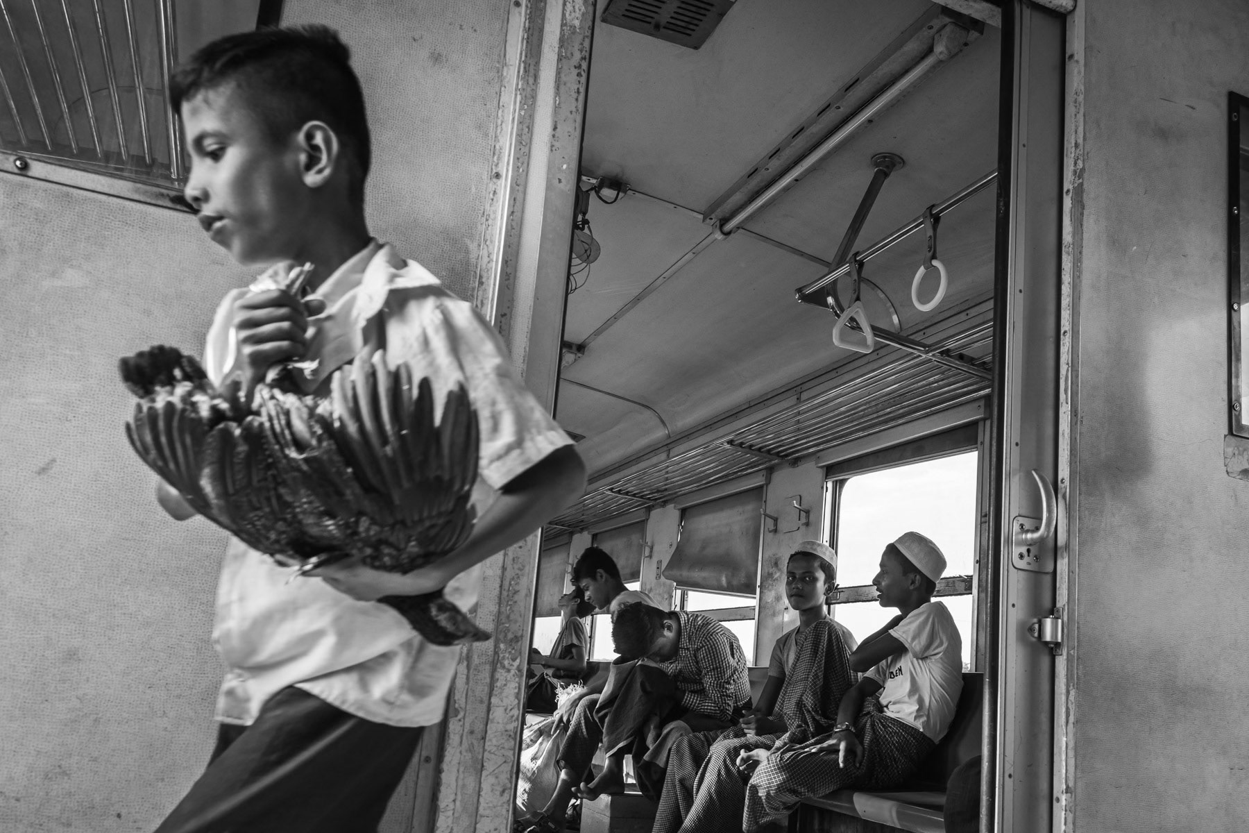 Rohingya minority travelling on the local train between the IDP camps. They are not allowed to travel to Sittwe and the trains are guarded by heavily armed police forces. Sittwe township, Myanmar, September 2019