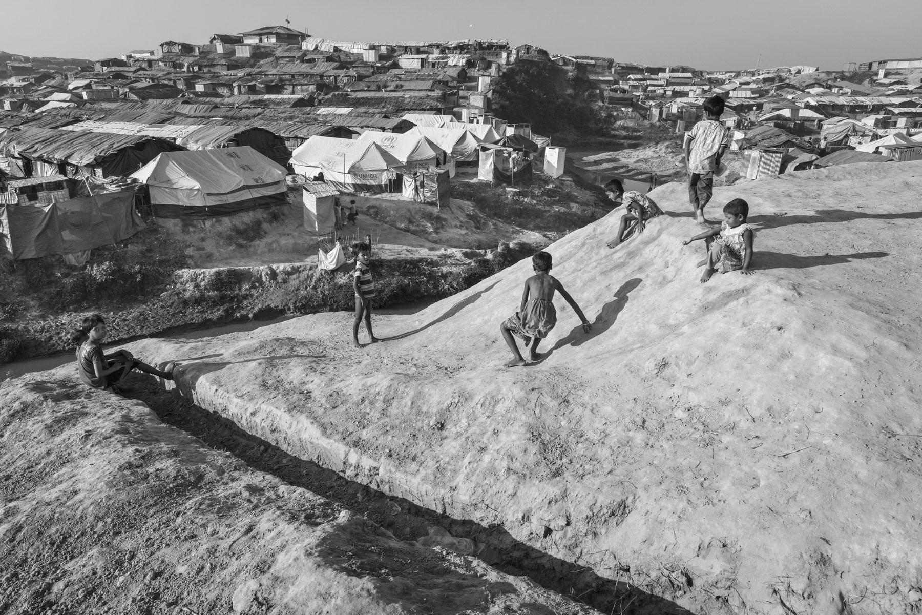 Children playing near a new extension of the already huge Kutupalong refugee camp to shelter a part of the 650,000 newly arrived Rohingya refugees. Kutupalong camp is now sheltering Rohingya victims of the 1978, 1992, 2008, 2012, 2016 and 2017 ethnic cleansing campaigns. By the end of 2017 nearly one million Rohingya refugees live in Kutupalong, Bangladesh, November 2017