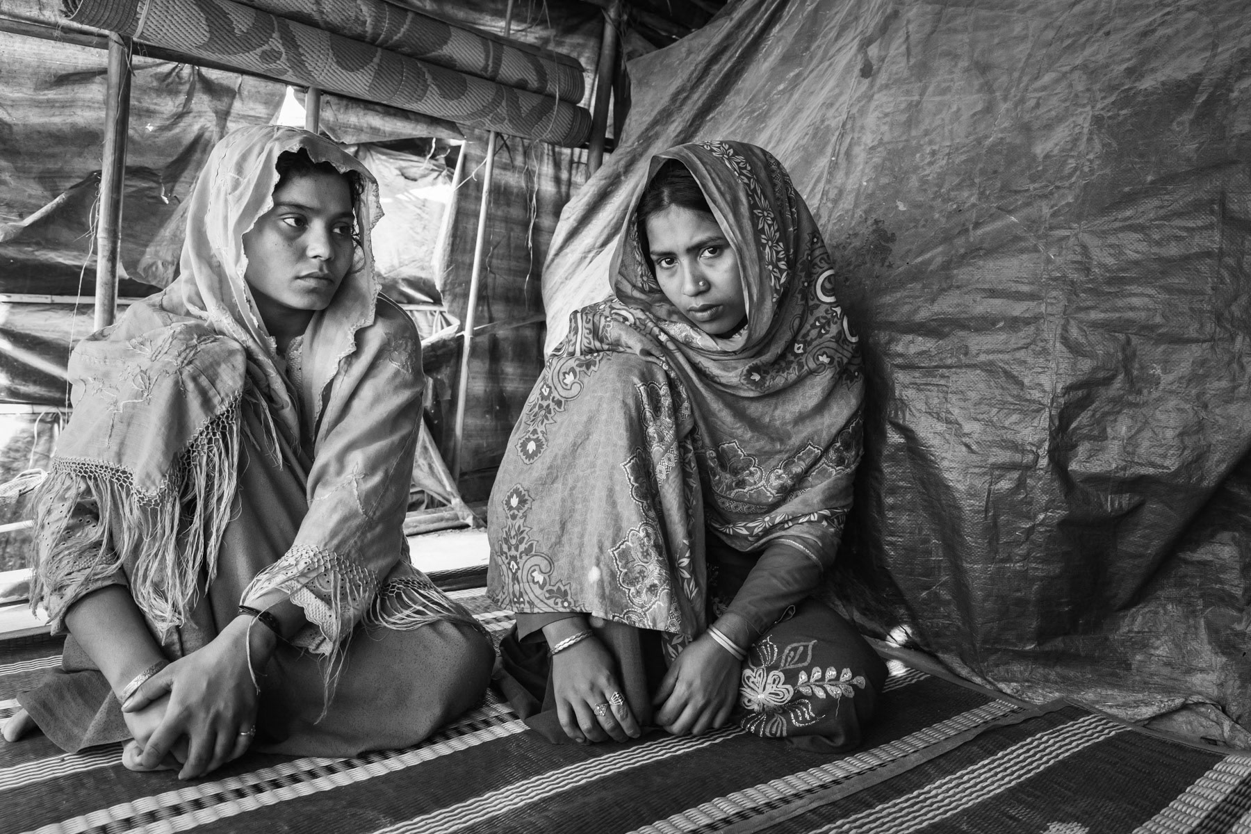Hasina Begum (right) and Roiza Khatun (left), respectively 20 and 23 years, from Chut Pyin, Rathedaung. Survivors of the Chut Pyin massacre and victims of extreme sexual violence. Chut Pyin village is one of the numerous Rohingya villages that have been totally wiped out and where severe acts of ethnic cleansing with genocidal intend have been committed by the military and local Rakhine mobs. Hundreds of Rohingya have been massacred and dozens of women have been gang-raped in this village alone. Tangkhali camp, Bangladesh, March 2018