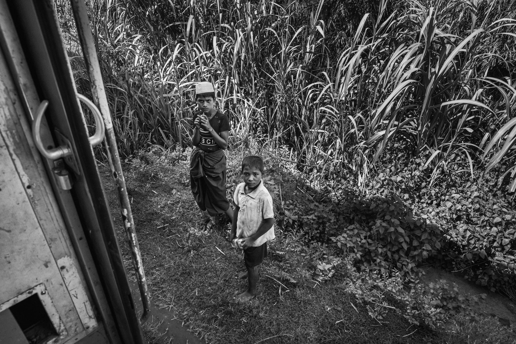 Rohingya children watching the train passing through the IDP camps north of Sittwe. Rakhine, Myanmar, September 2019