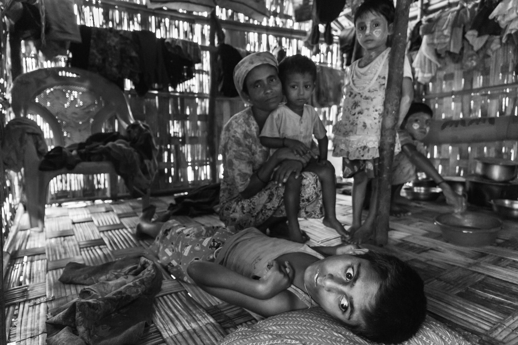 Child paralysed since birth with his family. Since the Rohingya population has been expelled from the city and forcibly placed in de-facto internment camps, the population has had no proper access to health care as the hospital remains off limit for the Rohingya. Dar Paing IDP camp near Sittwe, Myanmar, October 2016