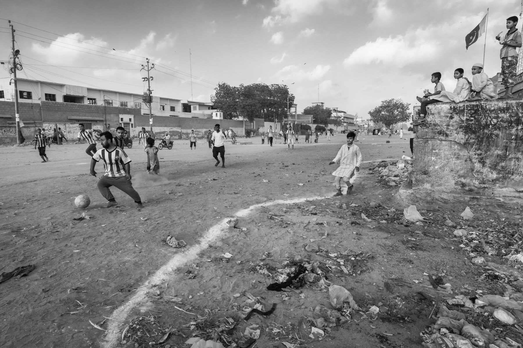 Kids watching a football game in Burma Colony, the largest Rohingya settlement in Karachi, Pakistan, March 2018