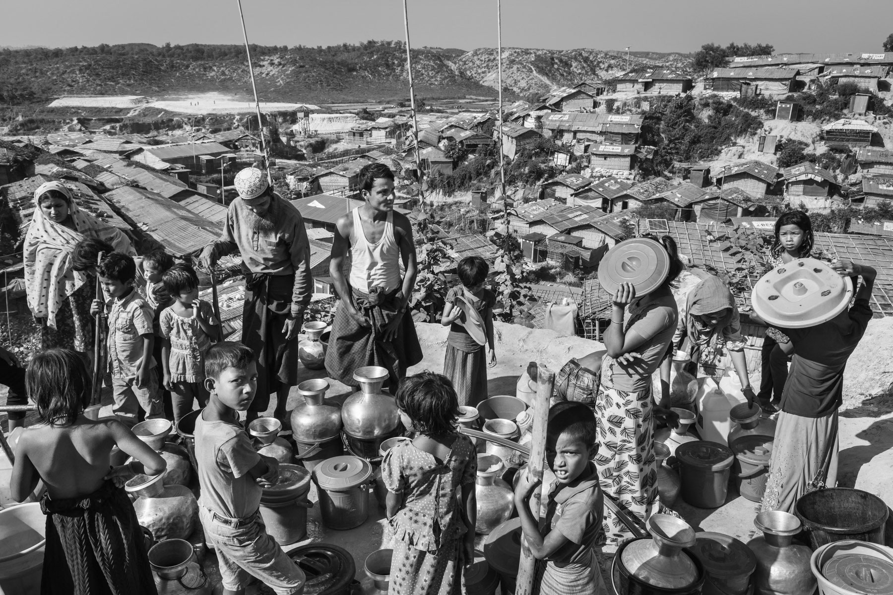 Children and adults waiting for water. Due to an overcrowded situation in the camps and shortage of available water, refugees have to wait long hours before tapping water. The shortage brings tensions and increases the risk of sanitary and health problems. Thangkhali refugee camp for Rohingya in Bangladesh, October 2018