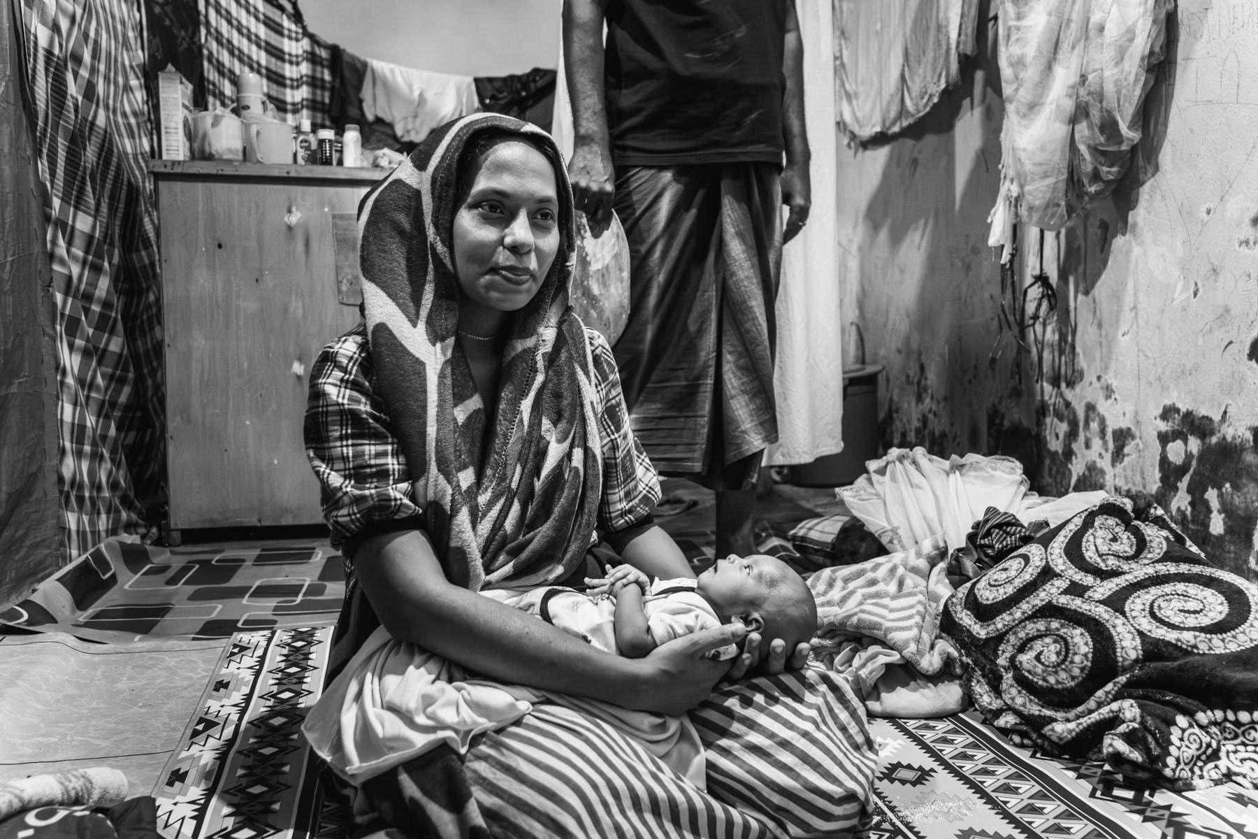 Rohingya woman from Sittwe in Myanmar and her newborn child and husband in a shelter for Rohingya refugees that were trafficked by boat and stranded along the coast of Sumatra in Indonesia. Padang Tijie shelter for Rohingya refugees, Aceh, Indonesia, May 2024