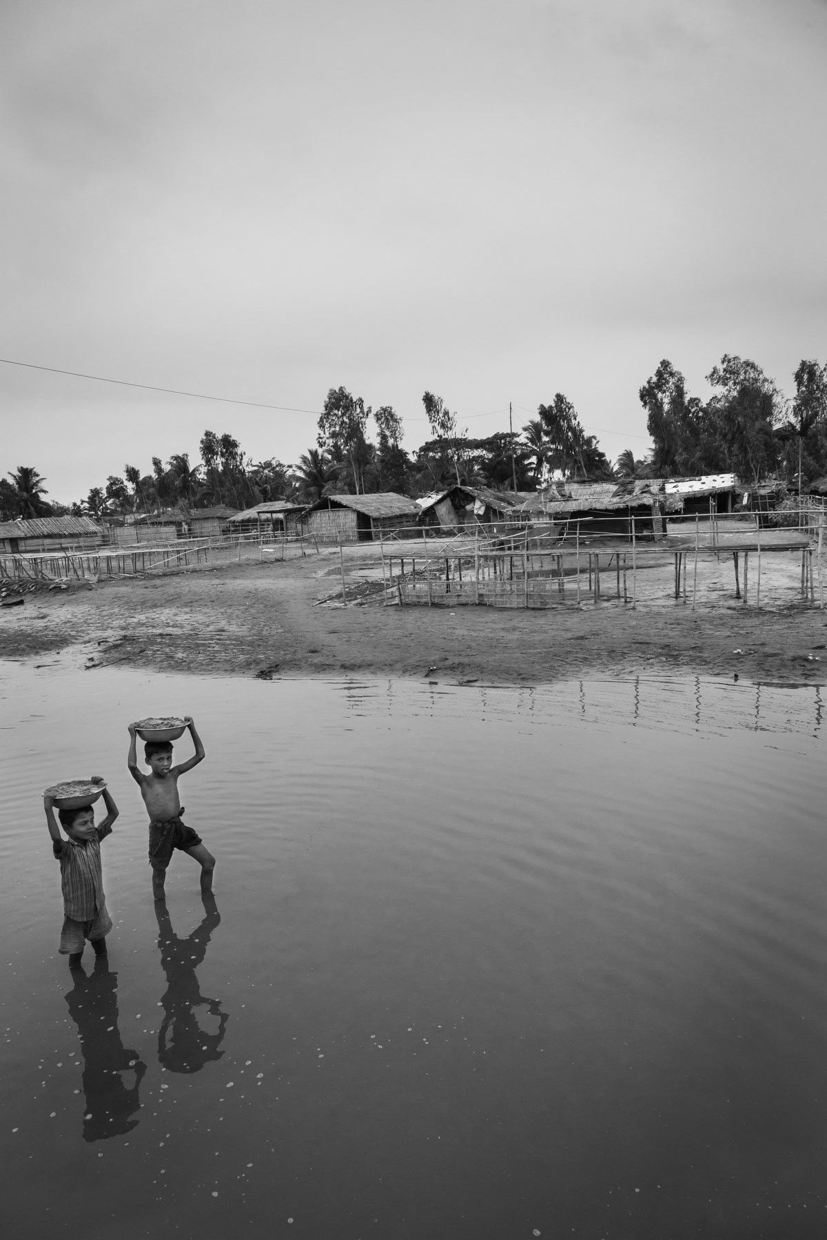 Rohingya children carrying sand through flooded areas after cyclone Roanu. Nazarir Tek, Cox's Bazar, Bangladesh, May 2016