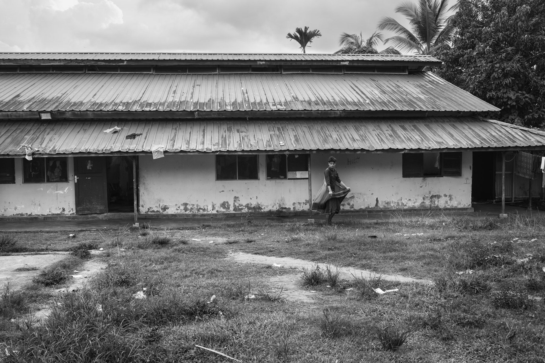 A Rohingya man in front of buildings previously used as an orphanage, now housing Rohingya boat people that escaped from Rakhine in Myanmar. The sea crossing takes usually 30-40 days and many people die due to exposure, lack of water and disease. Padang Pijie, Sumatra, Indonesia, October 2023