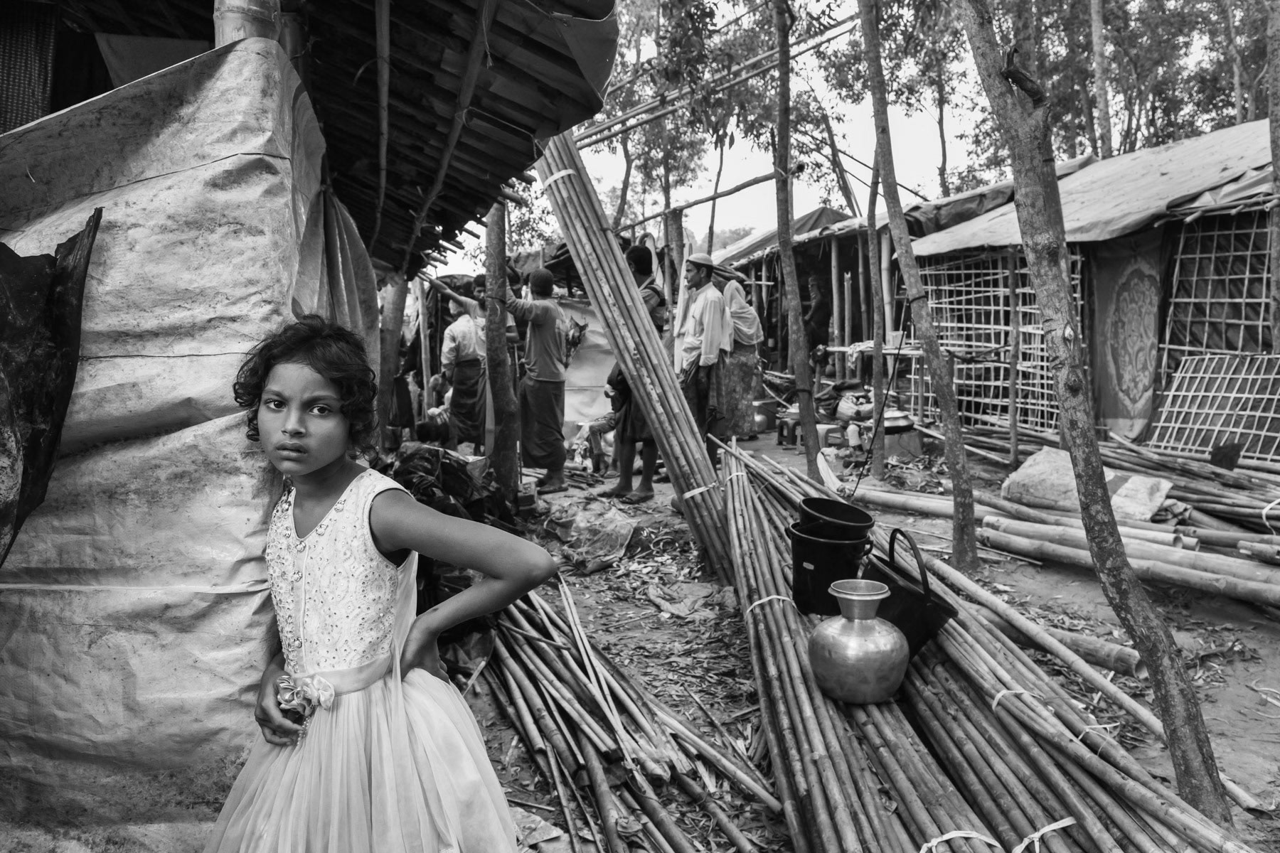 A Rohingya girl and her family that arrived few days earlier building their makeshift shelter with donated materials. The huge influx of refugees during the past months has put an enourmeous strain on the local environment and economy resulting in substantial deforestation, price hikes and tensions with the local community. Lambashiya section of Kutupalong refugee camp, Ukhiya, Bangladesh, November 2017