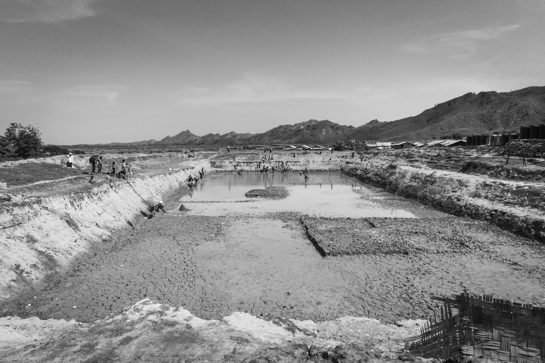 The last avaiable water at the end of the dry season, requiring infected pumped water from the river to provide drinking water. The pond is the only source of drinking water for the 8,000 strong camp population. No tube wells because the soil is too rocky. Acute shortages of water during dry season. The unclean water is causing high levels of diarrhea and a breeding ground for mosquito's causing malaria and dengue fever. The closest hospital is in Sittwe requiring a police permission to go to, and takes several hours by boat. Kyin Ni Pyin IDP Camp near Paktauw, Myanmar, May 2017