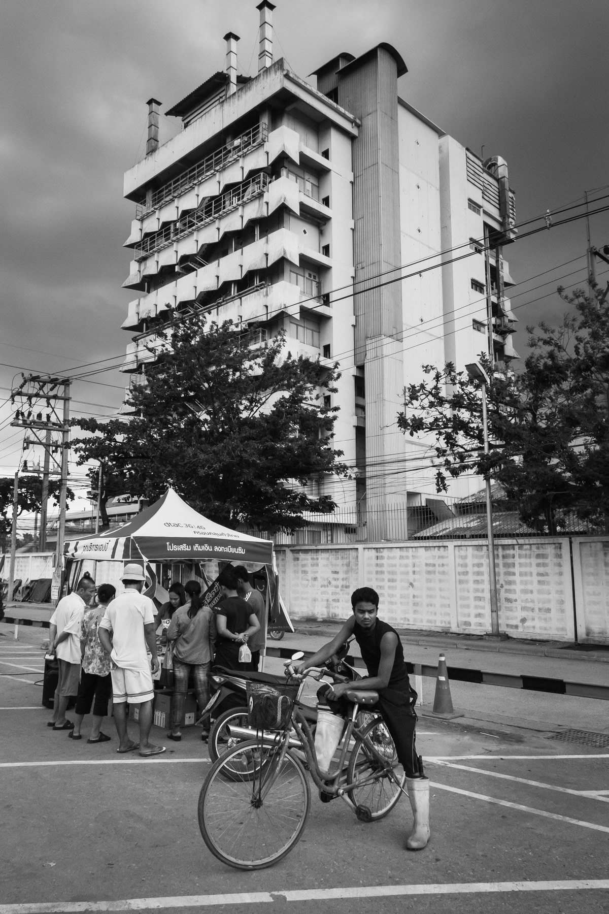 Rohingya refugee after his shift in the chicken processing factory in the background. Bangkok, Thailand, June 2016