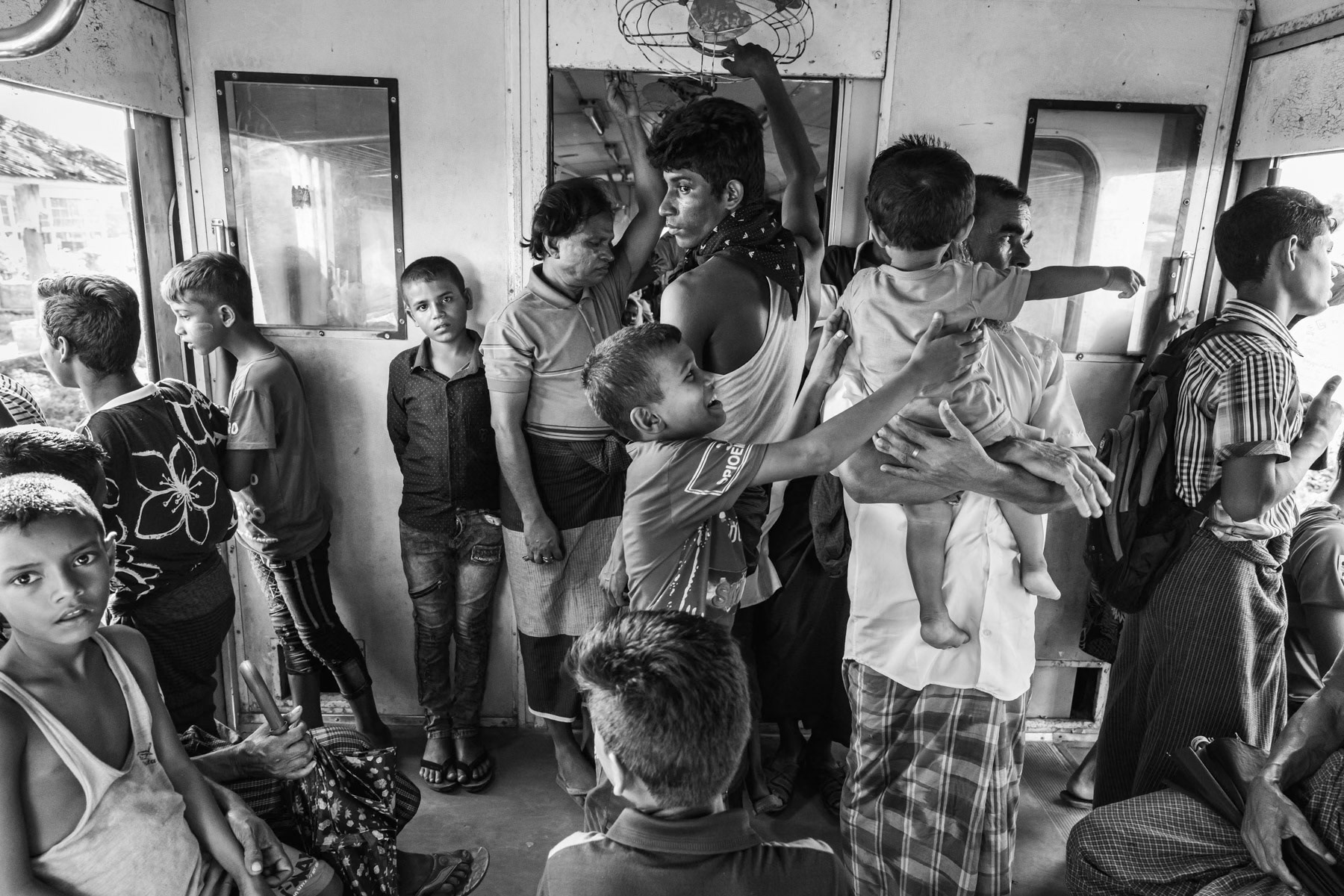Rohingya minority travelling on the local train between the IDP camps. They are not allowed to travel to Sittwe and the trains are guarded by heavily armed police forces. Sittwe township, Myanmar, September 2019