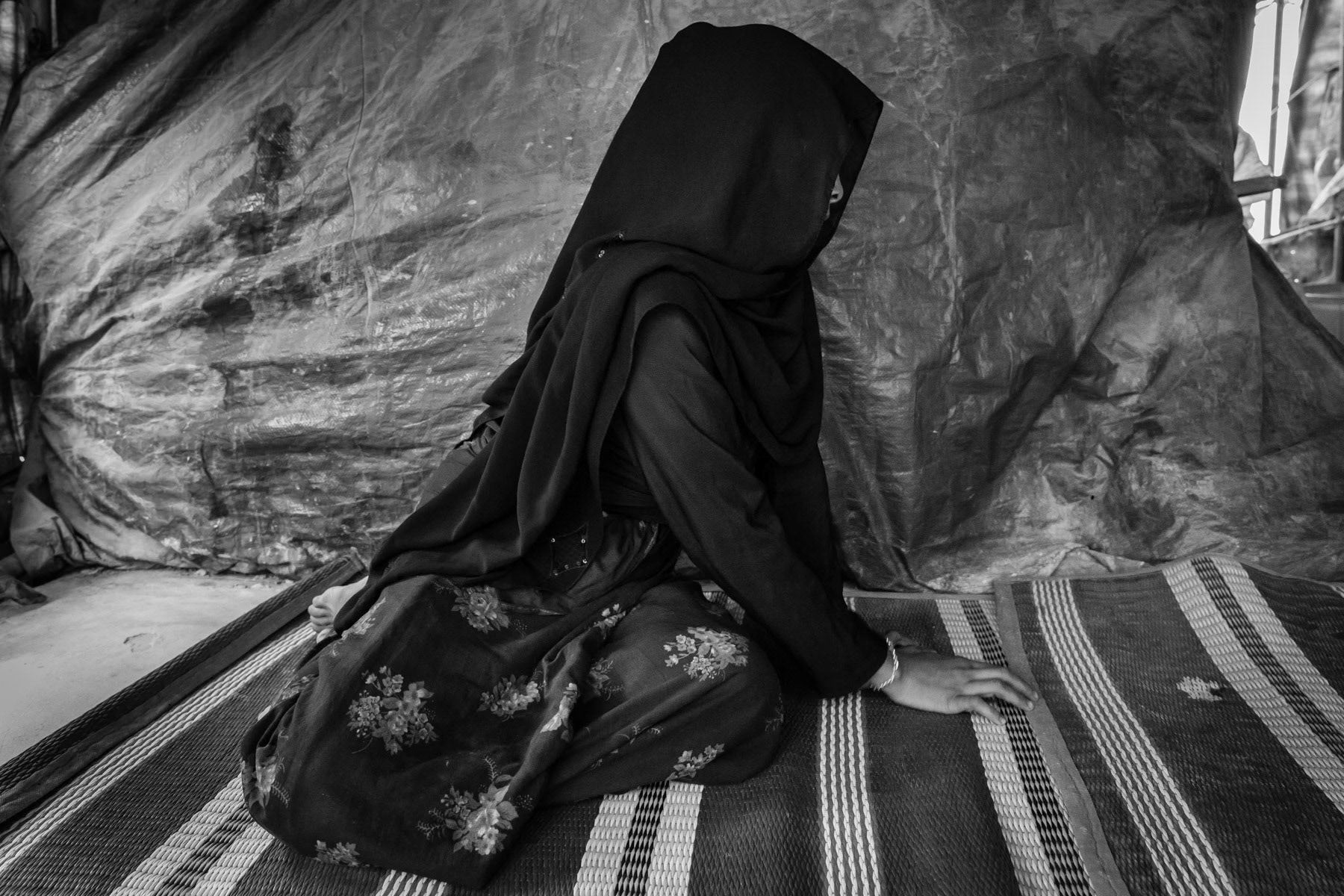 Nur Begum, 25 years from Chut Pyin, Rathedaung. Arrived in September 2017 in Bangladesh. Her husband was killed when their village was attacked end August 2017. She is a victim of torture and rape. She fled to Bangladesh with her 3 sons and daughter, it took them 7 days to reach the Bangladeshi borde. Her father was also killed, being a lone mother she survives on the rations refugees are receiving. She is a refugee for the second time after having fled with her patents in the nineties when she was a young child. She now fled herself with her four children. As she says "I has never known a moment of hapiness in my life since I was born" She was gang-raped by military and local rakhine mobs with 4 other women from the village. While they were assaulted and raped raped their assailants cut off a breast of one of the women. They were taken in a remote place in the hills where they were raped continously by 10-12 people for 5-6 hours. Off the five women all were killed except her. She thinks she was not killed because she was with her 6 month old baby. The other women were decapitated. When she returned to the village to find her family she witnessed between 400 and 500 dead bodies of Rohingya villagers. Among them she saw her brother and sister in law and her father. Chut Pyin village is one of the numerous Rohingya villages that have been totally wiped out and where severe acts of ethnic cleansing with genocidal intend have been committed by the military and local mobs. Hundreds of Rohingya have been massacred in this village alone. Tangkhali camp, Bangladesh, March 2018