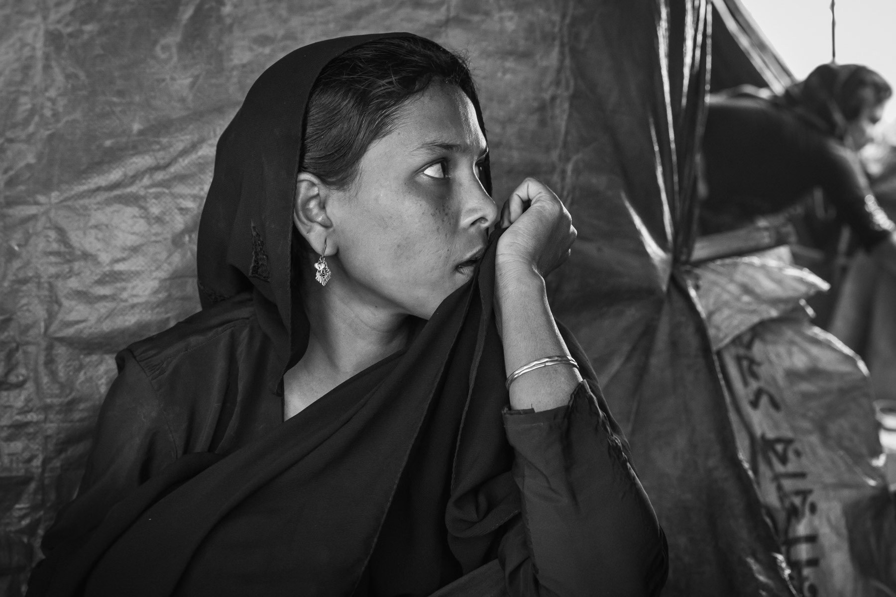 Nur Begum, 25 years from Chut Pyin, Rathedaung. Arrived in September 2017 in Bangladesh. Her husband was killed when their village was attacked end August 2017. She is a victim of torture and rape. She fled to Bangladesh with her 3 sons and daughter, it took them 7 days to reach the Bangladeshi borde. Her father was also killed, being a lone mother she survives on the rations refugees are receiving. She is a refugee for the second time after having fled with her patents in the nineties when she was a young child. She now fled herself with her four children. As she says "I has never known a moment of hapiness in my life since I was born" She was gang-raped by military and local rakhine mobs with 4 other women from the village. While they were assaulted and raped raped their assailants cut off a breast of one of the women. They were taken in a remote place in the hills where they were raped continously by 10-12 people for 5-6 hours. Off the five women all were killed except her. She thinks she was not killed because she was with her 6 month old baby. The other women were decapitated. When she returned to the village to find her family she witnessed between 400 and 500 dead bodies of Rohingya villagers. Among them she saw her brother and sister in law and her father. Chut Pyin village is one of the numerous Rohingya villages that have been totally wiped out and where severe acts of ethnic cleansing with genocidal intend have been committed by the military and local mobs. Hundreds of Rohingya have been massacred in this village alone. Tangkhali camp, Bangladesh, March 2018