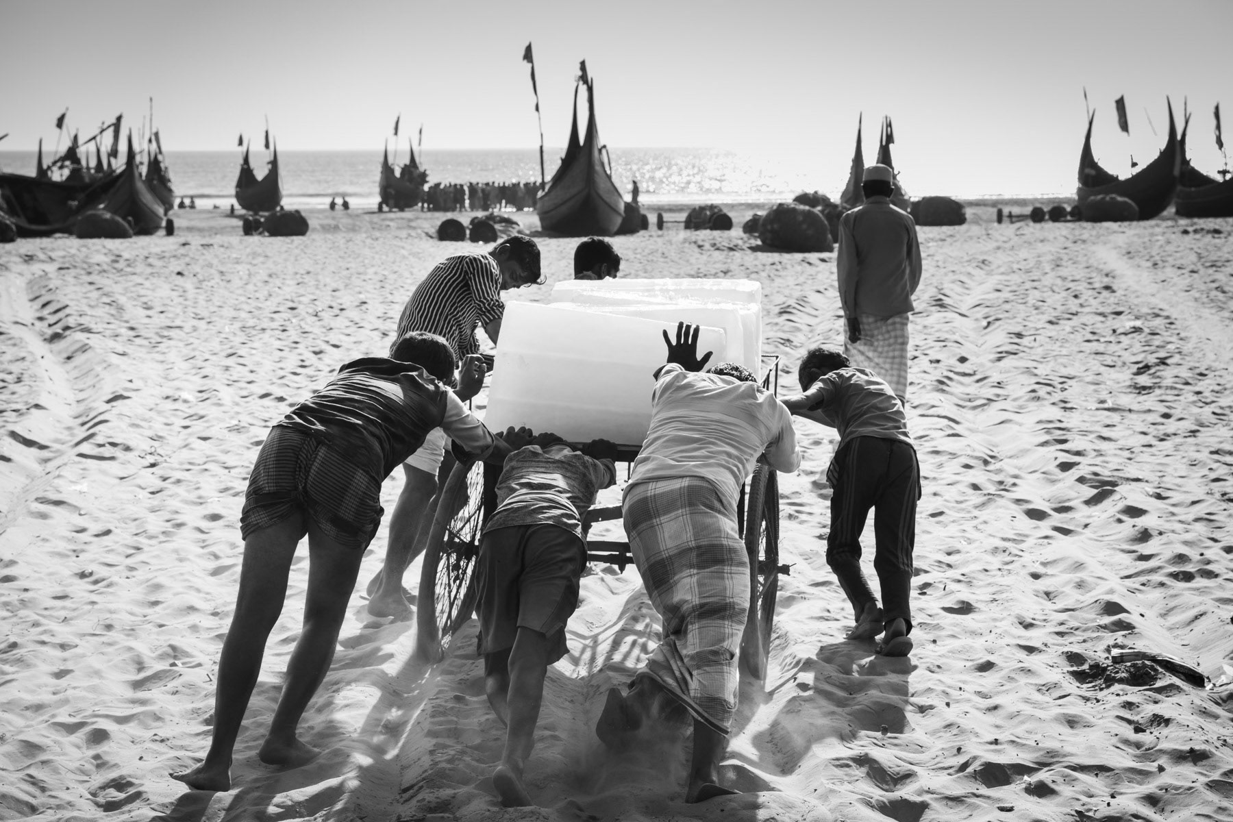 Rohingya daily labour carrying ice blocks to the fishing boats. The boat owners are local and cash-in the bulk of the money made. Daily labour make between 1 and 3 dollar a day, sometimes less. Shamlapur near Teknaf, Bangladesh, February 2017