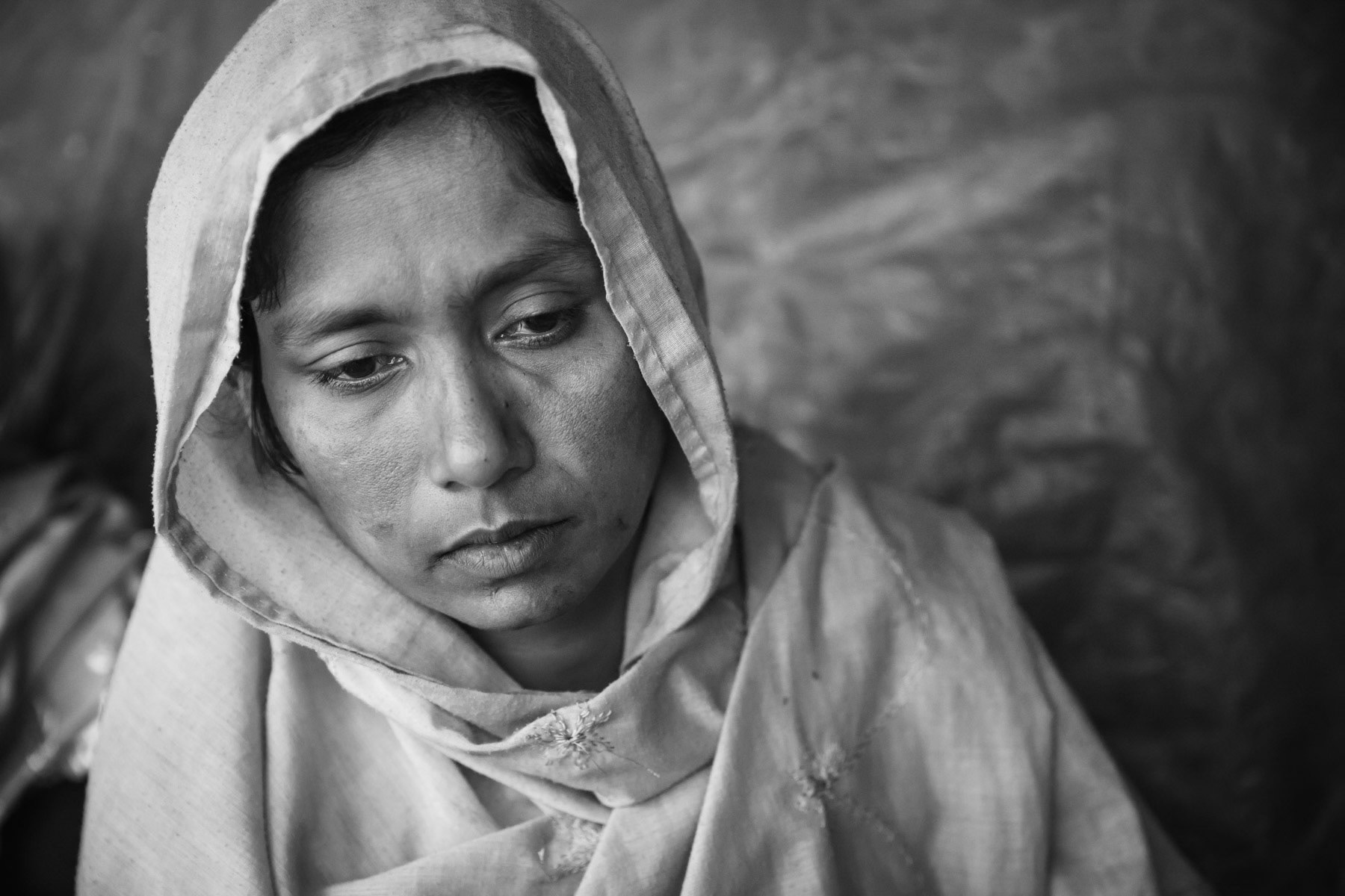 Fatima Khatun, 28 years, from Chut Pyin, Rathedaung. Her father, husband and 8 month old son were killed and decapitated. She was gang-raped twice, once by the military and a second time she was taken away and raped by several local Rakhine residents. When the military attacked the village, most of the men would be killed, the ones surviving are the ones that were hiding in the woods. The women and young girls were rounded up and about 50 of them were selected to be raped in different locations in the area. After being tortured and raped by the military, they would be taken by local Rakhine mobs to be gang-raped again in another locations. She was not blindfolded so could recognize all her rapists which were all from the same area. She fled to Bangladesh with her 3 remaining sons of 6, 8, 10 years old that had managed the flee when the military and local mobs came to the house. Chut Pyin village is one of the numerous Rohingya villages that have been totally wiped out and where severe acts of ethnic cleansing with genocidal intend have been committed by the military and local mobs. Hundreds of Rohingya have been massacred in this village alone. Tangkhali camp, Bangladesh, March 2018