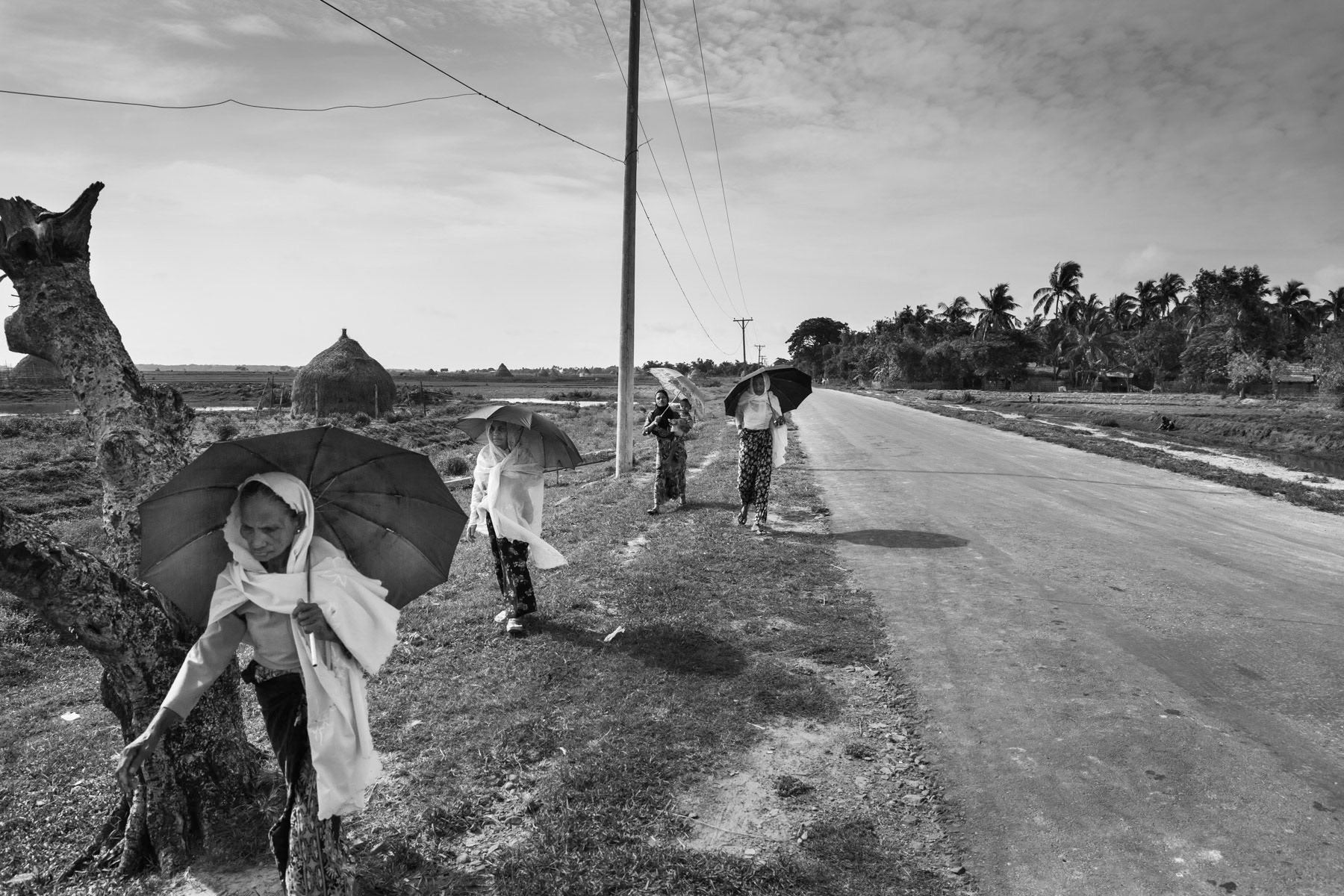 Rohingya women going to the trainstation. The train is the only public transport between Rohingya villages and the IDP camps north of Sittwe. Main road in Rashimi, Sittwe township, Myanmar, June 2016