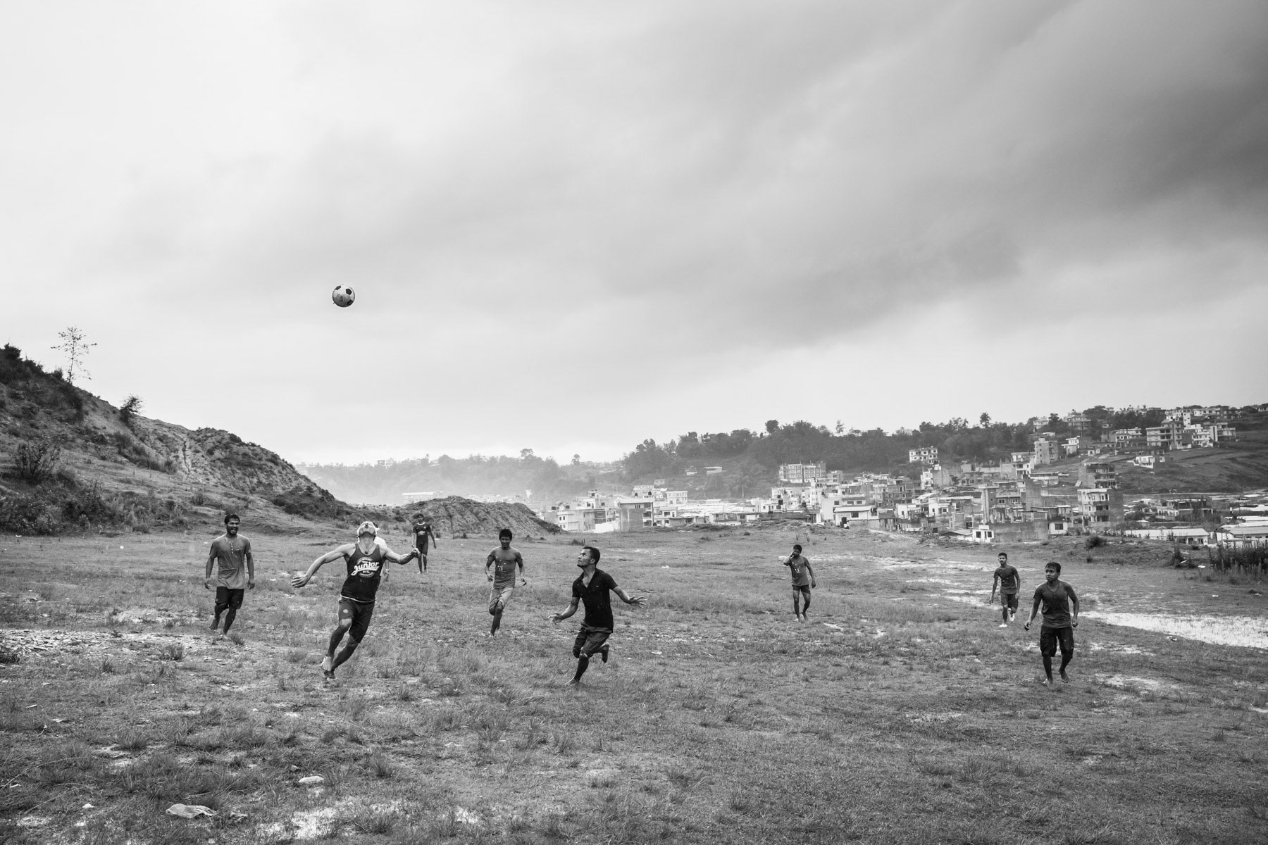 Rohingya refugees from Myanmar playing football at the beginning of the monsoon season. Kathmandu Valley, Nepal, July 2017