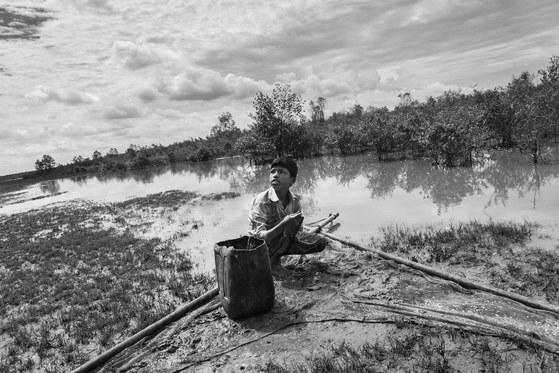 Rohingya boy catching small fish. Maheskhali peninsula, Bangladesh, May 2016