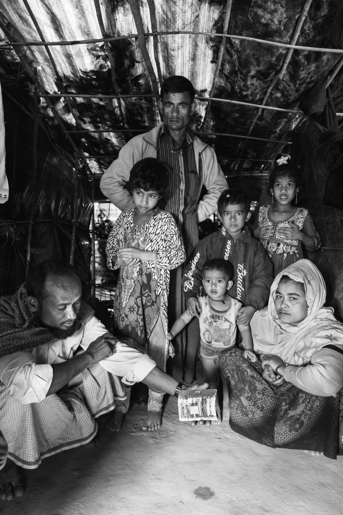Rape victim reached safety alone with her children after her husband went into hiding. Her husband holding a family photo has recently joined her in Bangladesh. Kutupalong refugee camp extension for newly arrived Rohingya refugees from Myanmar, South Bangladesh, February 2017