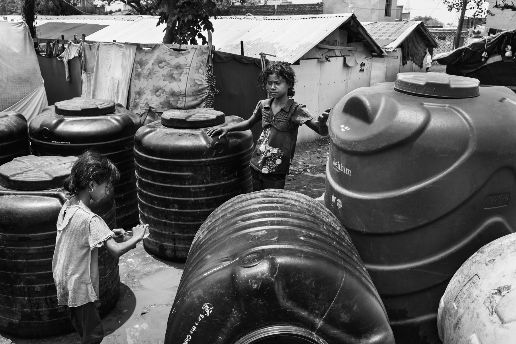 Water tanks waiting to be filled, makeshift camp for Rohingya refugees in Jammu, India, June 2017