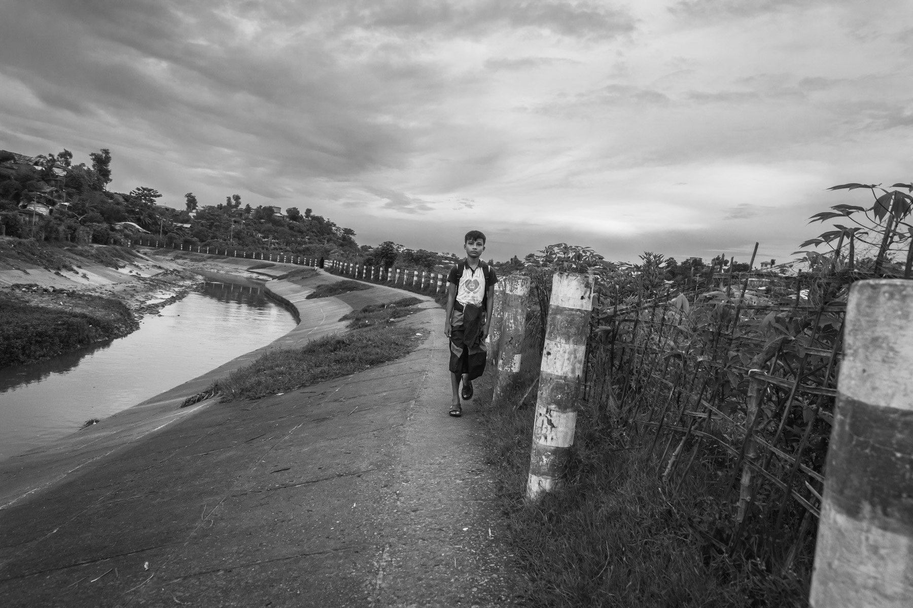 Rohingya refugee from Myanmar exiting a refugee camp. All the refugee camps for Rohingya have been sealed off with barbed wire fences and became de-facto like open-air prisons. Movements in and out the refugee camp area is heavily restricted. More than one million Rohingya refugees live in the camps with no perspective of return to their homeland or re-settlement in a third country. Kutupalong refugee camp, Ukhiya, Cox's Bazar, Bangladesh, September 2022