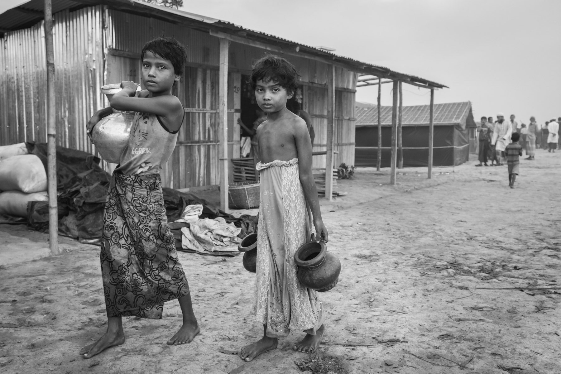 Rohingya children carrying water from one of the few tube wells in the refugee camp for new arrivals. More than 650,000 Rohingya refugees have arrived in Bangladesh since August 2017. Lamabashiya section in Kutupalong, November 2017