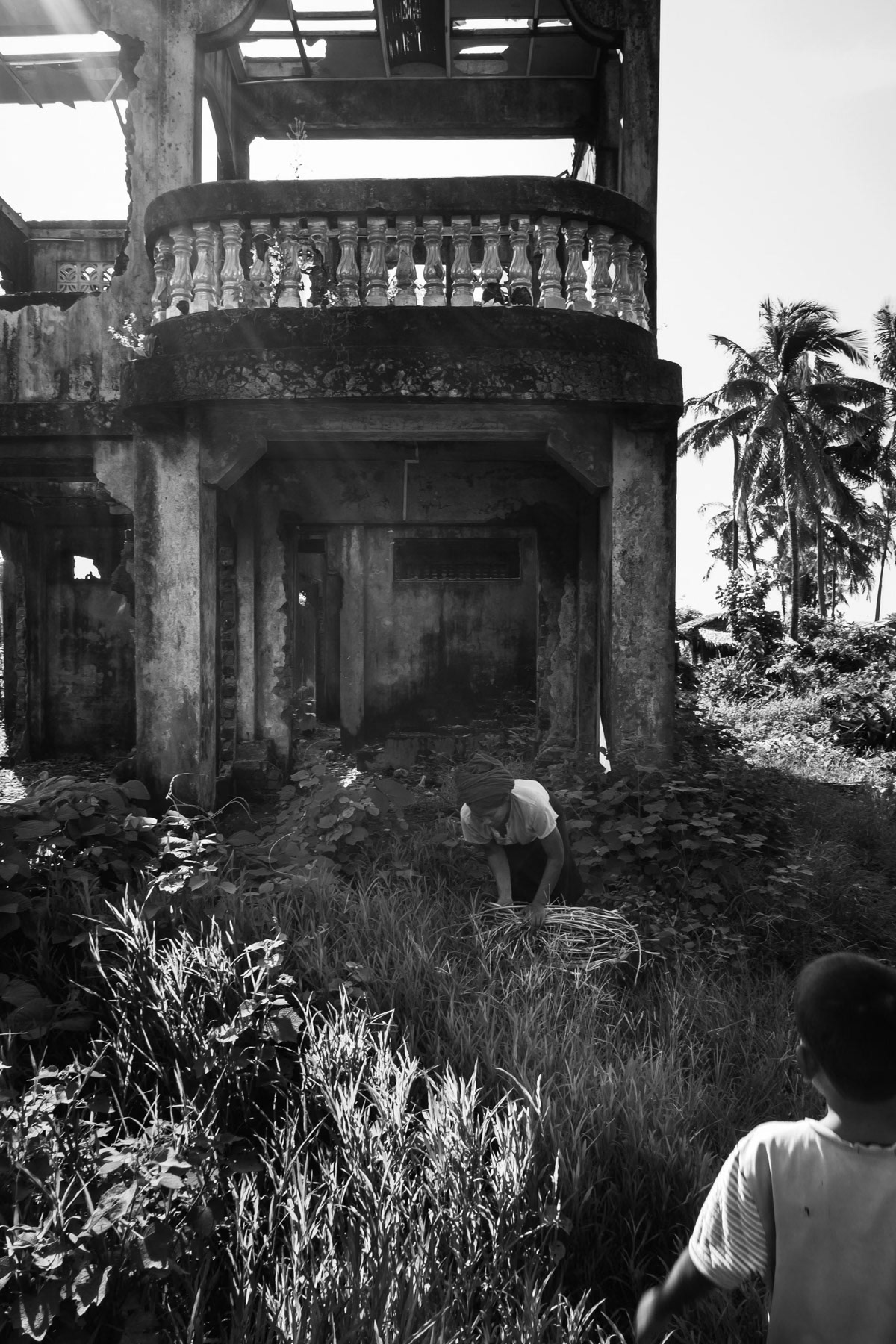 A woman collecting wood in an abandonned house of an ethnically cleasned neighbourhood of Sittwe where Rohingya Muslims used to live before being forcibly expelled in 2012. Naziri neighbourhood in Sittwe the capital of Rakhine State, Myanmar, October 2016