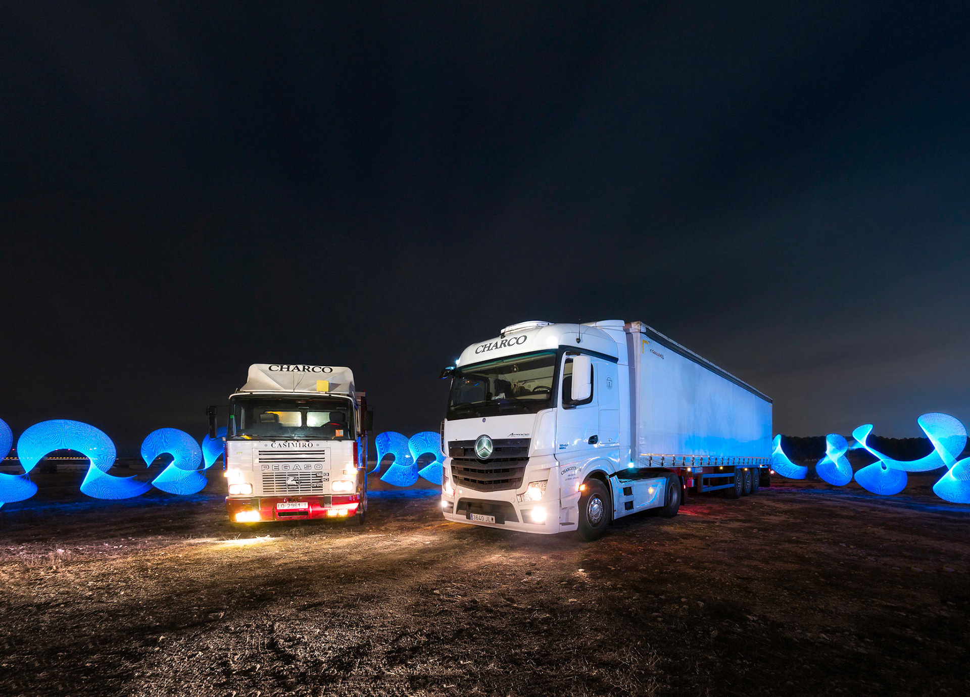 Fotografía nocturna de larga exposición de camiones de CharcoTrans.