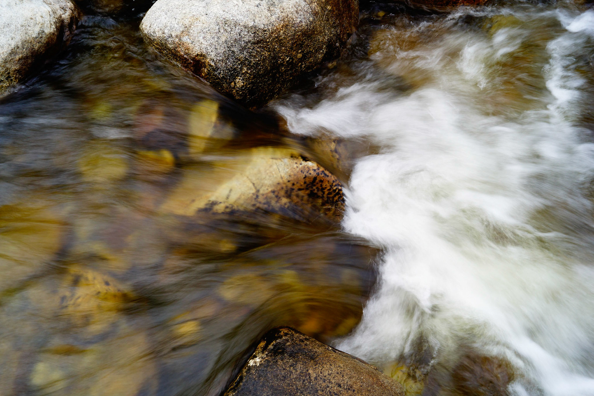 Creek water flowing over the rocks and if you stare you can see the profile of a mans face with a big nose spitting the water out of his mouth.