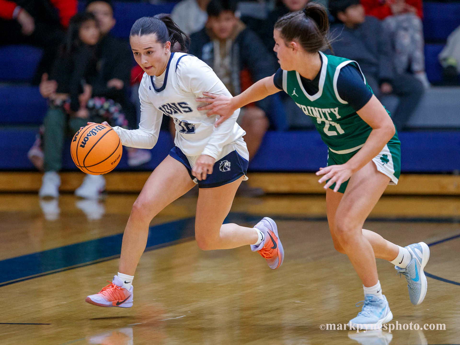 Cecilia Battisti drives up court under heavy defense from Kenzie Fox, and Trinity wins 61-16.