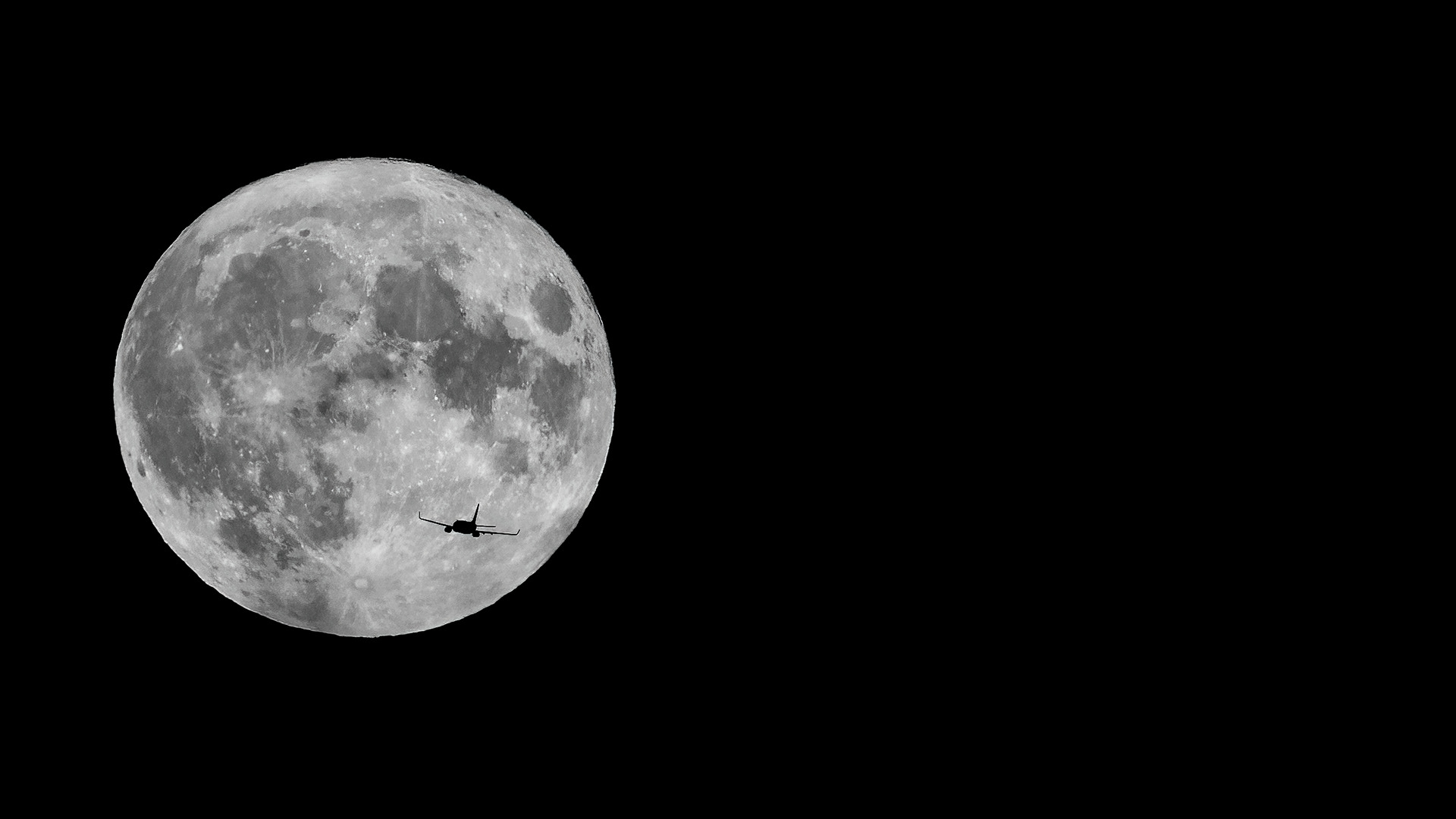 Plane coming in to land at Leeds Bradford Airport with the supermoon in the background