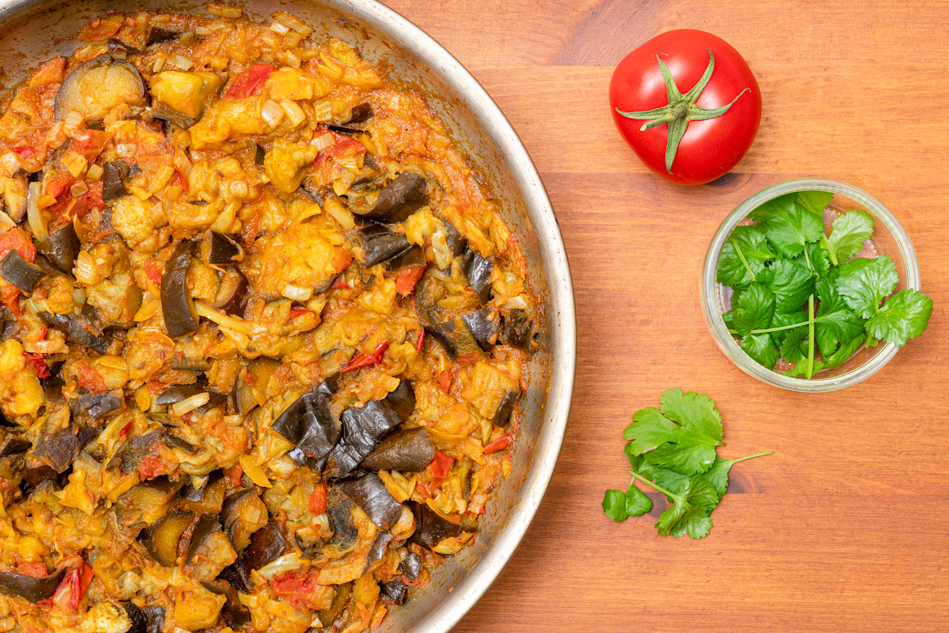 Homemade aubergine or eggplant cooked in spices with onions and tomatoes. Egg plant curry cooked Indian style. Top view.