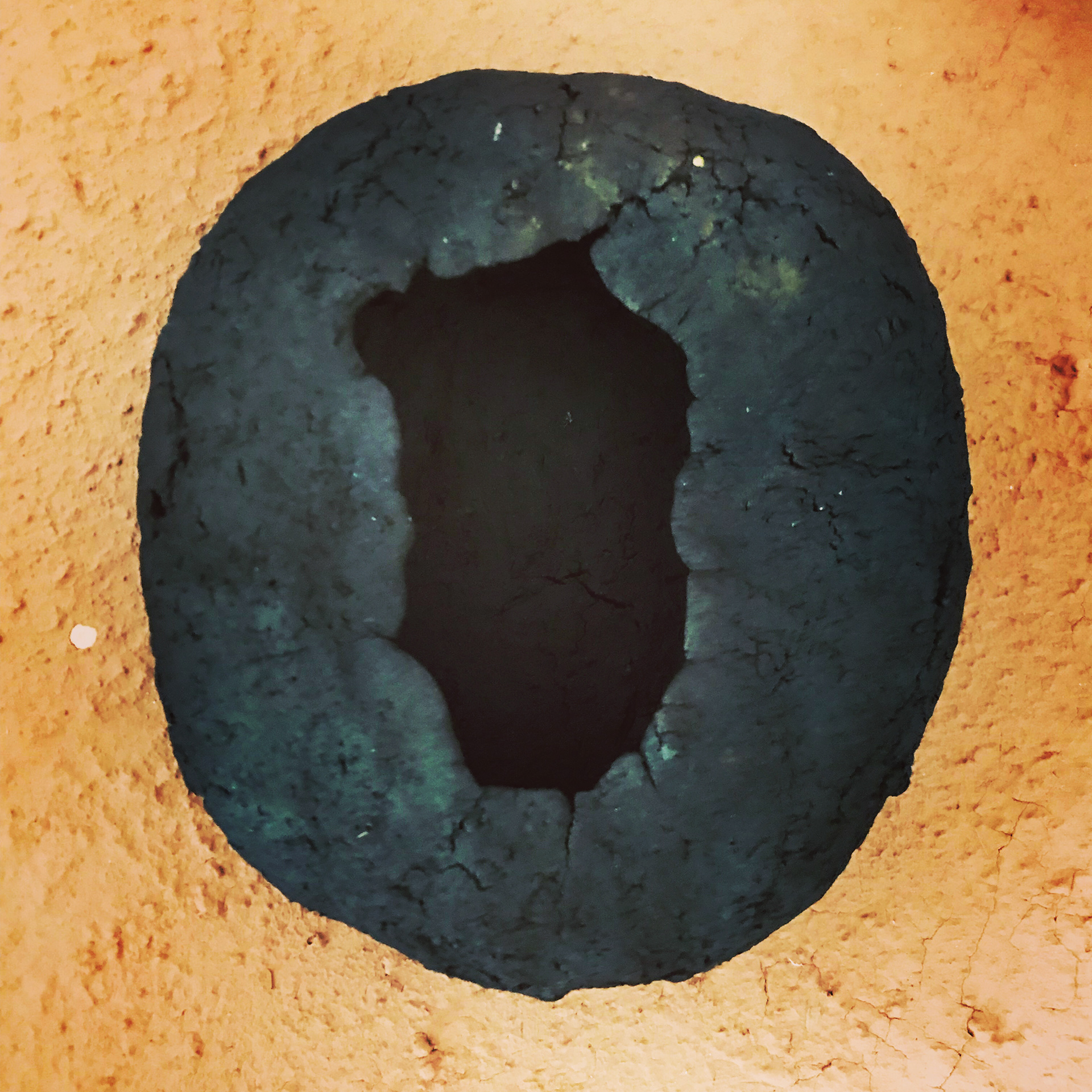 Raw, unrefined North Herefordshire clay pinch pot, wood fired, straw reduction, placed upon unfired sample of the same clay