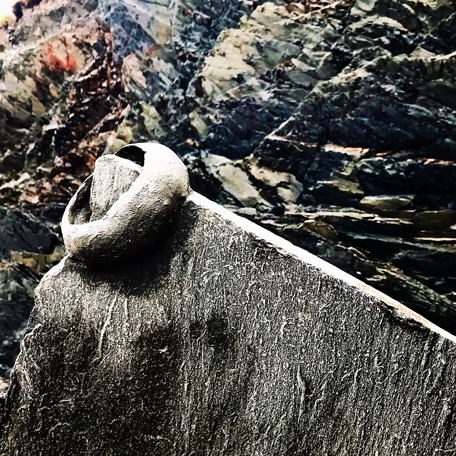Beach clay, rock outcrop. Clay bowl formed over rock, coated with sand. Rain and waves washed it away