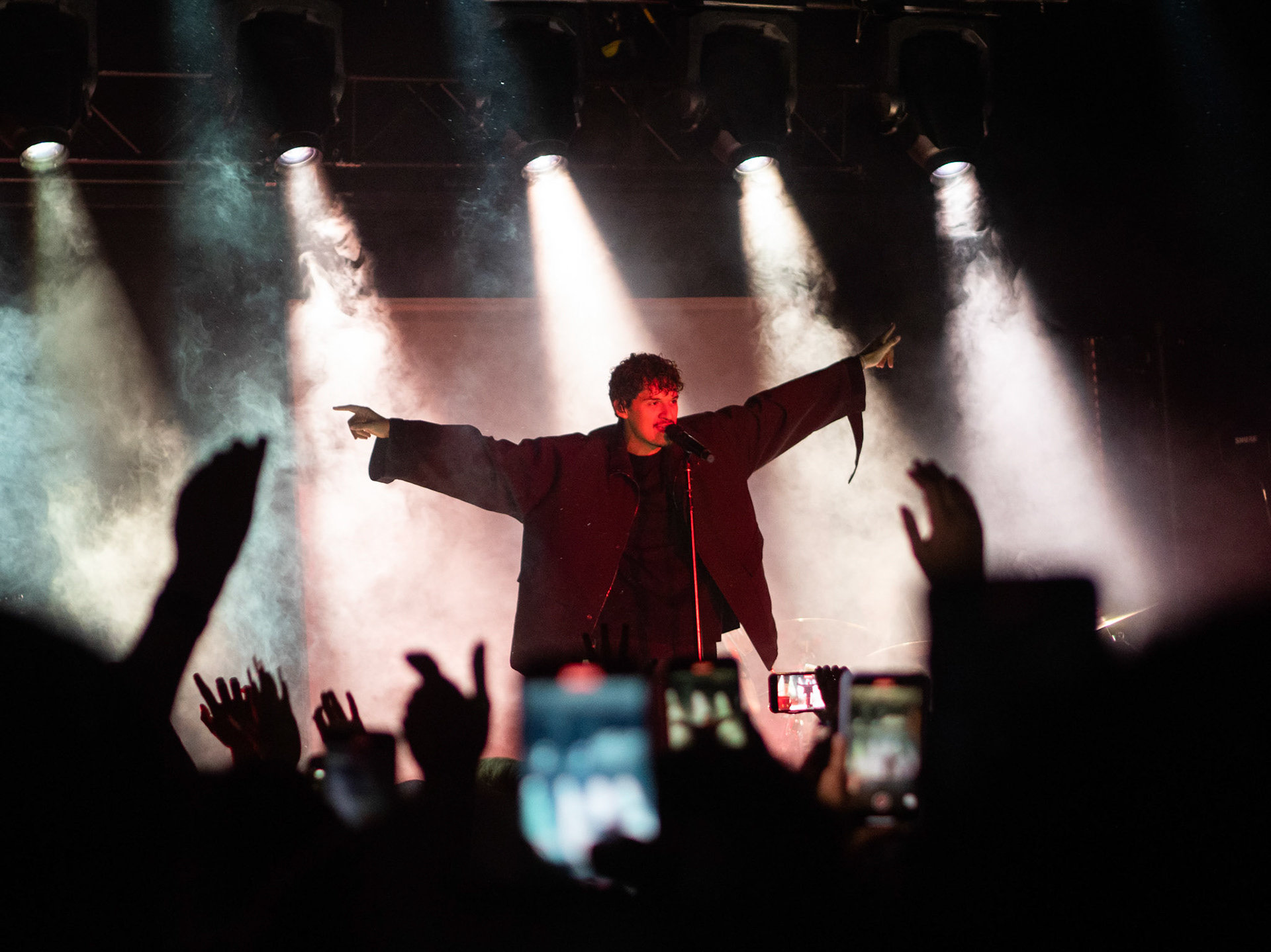 Omar Apollo with his hands spread apart at 151 Toole on the Prototype tour. This councert took place on Saturday October 22 2022.