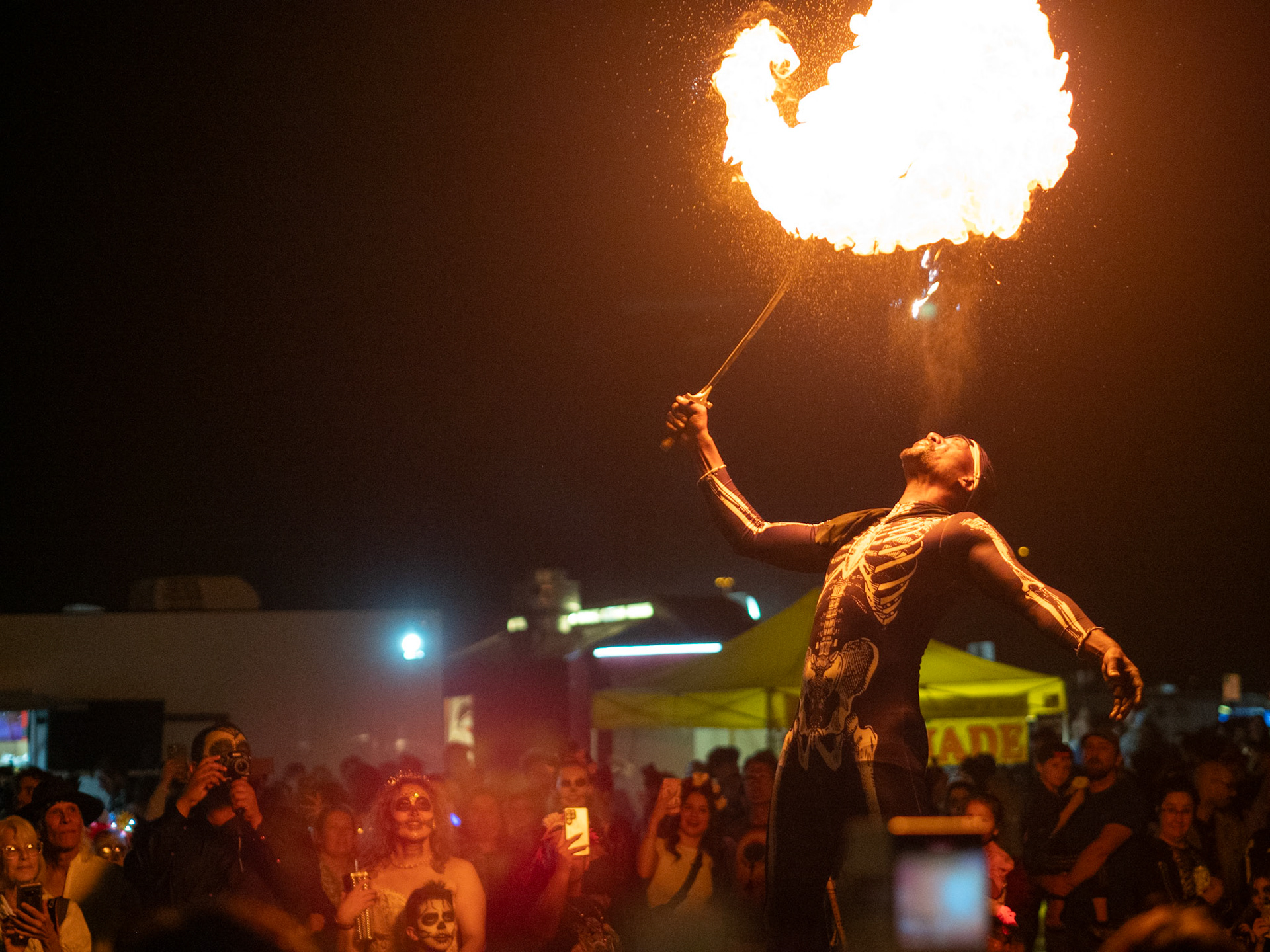 A performer plays with fire at the All Souls Procession on Nov. 5 in Tucson. After the procession, performers and food trucks were available for the crowd. Un artista juega con fuego durante la Procesión de Todas las Almas en Nov. 5. Después de la procesión, los artistas y los camiones de comida estaban disponibles para la multitud.
